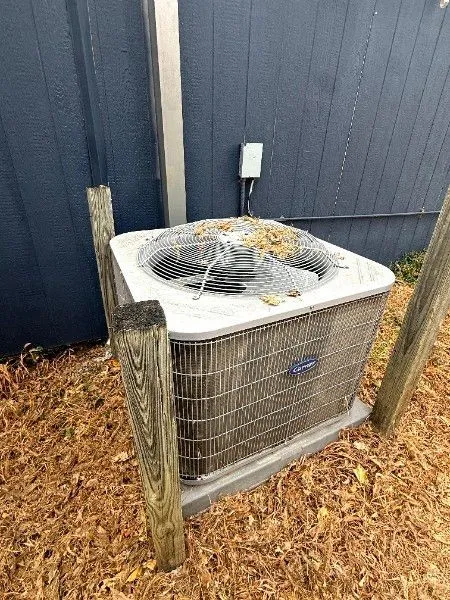 Exterior Carrier HVAC condenser unit mounted on a concrete pad
