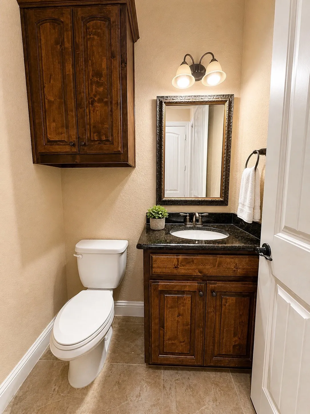Bathroom vanity with dark wood cabinetry and a dark stone countertop featuring an undermount sink