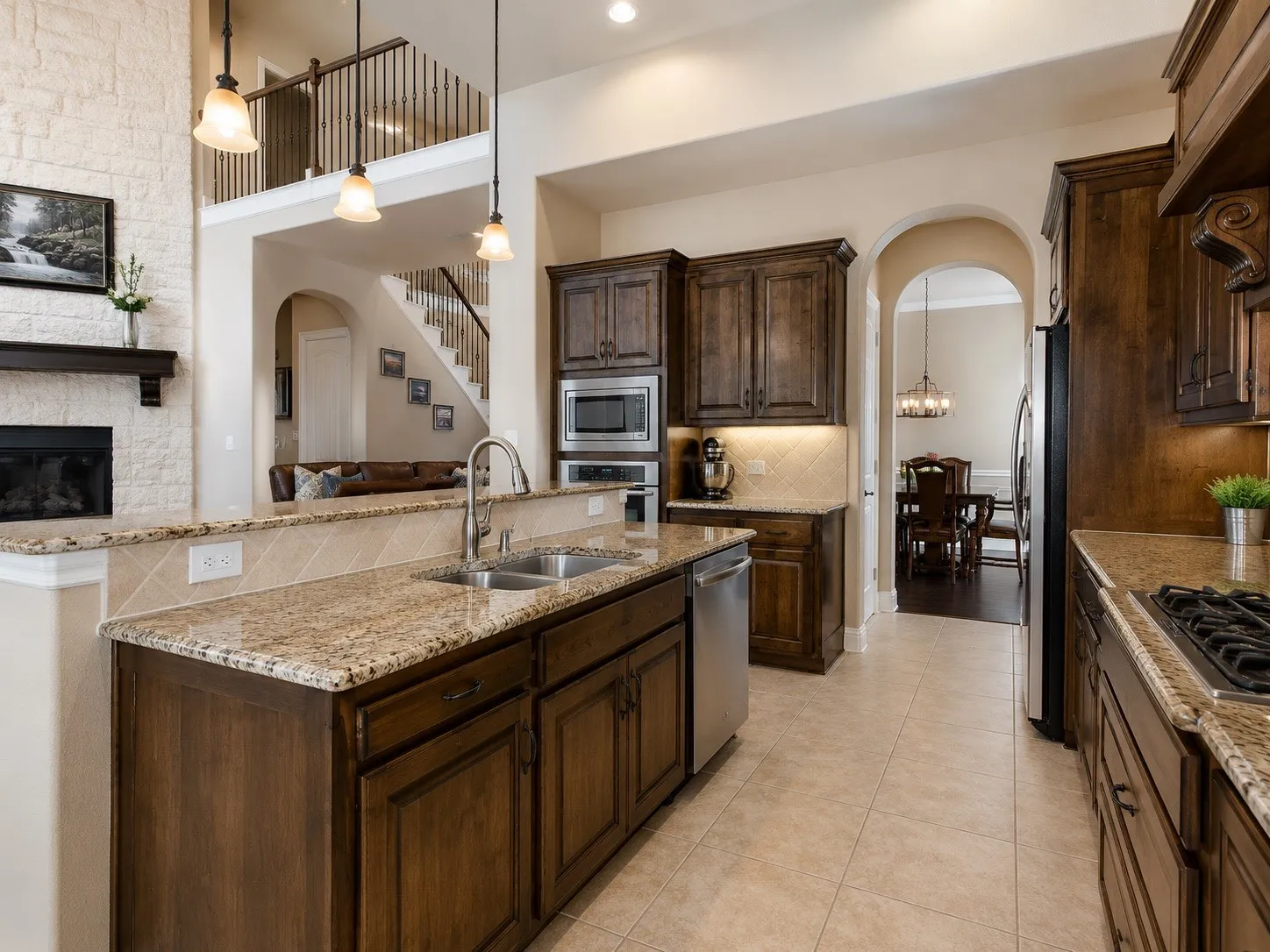Gourmet kitchen with wood-finish cabinetry, granite countertops, and stainless steel appliances