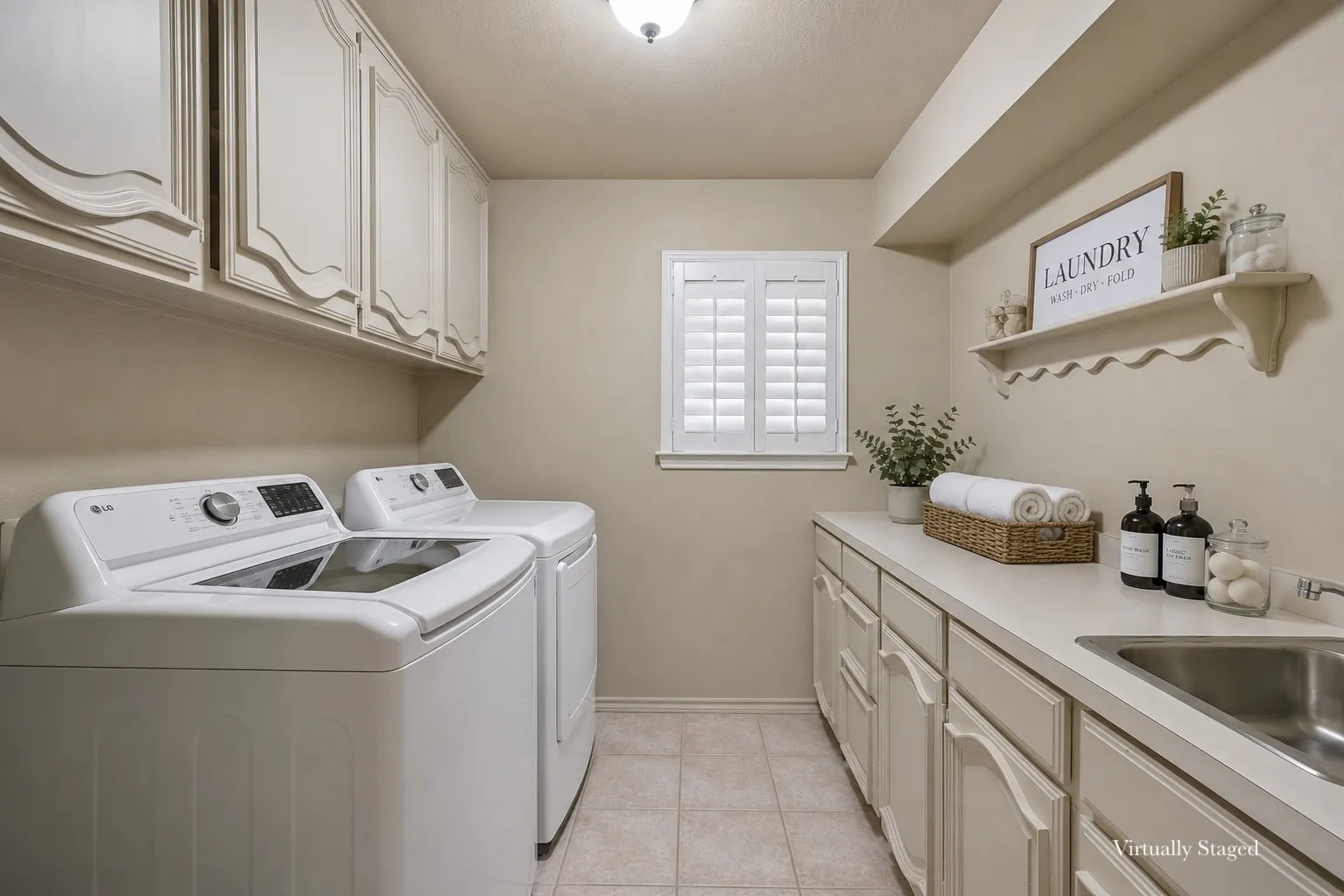 Utility room with ample cabinetry, a built-in countertop, and an integrated stainless steel sink