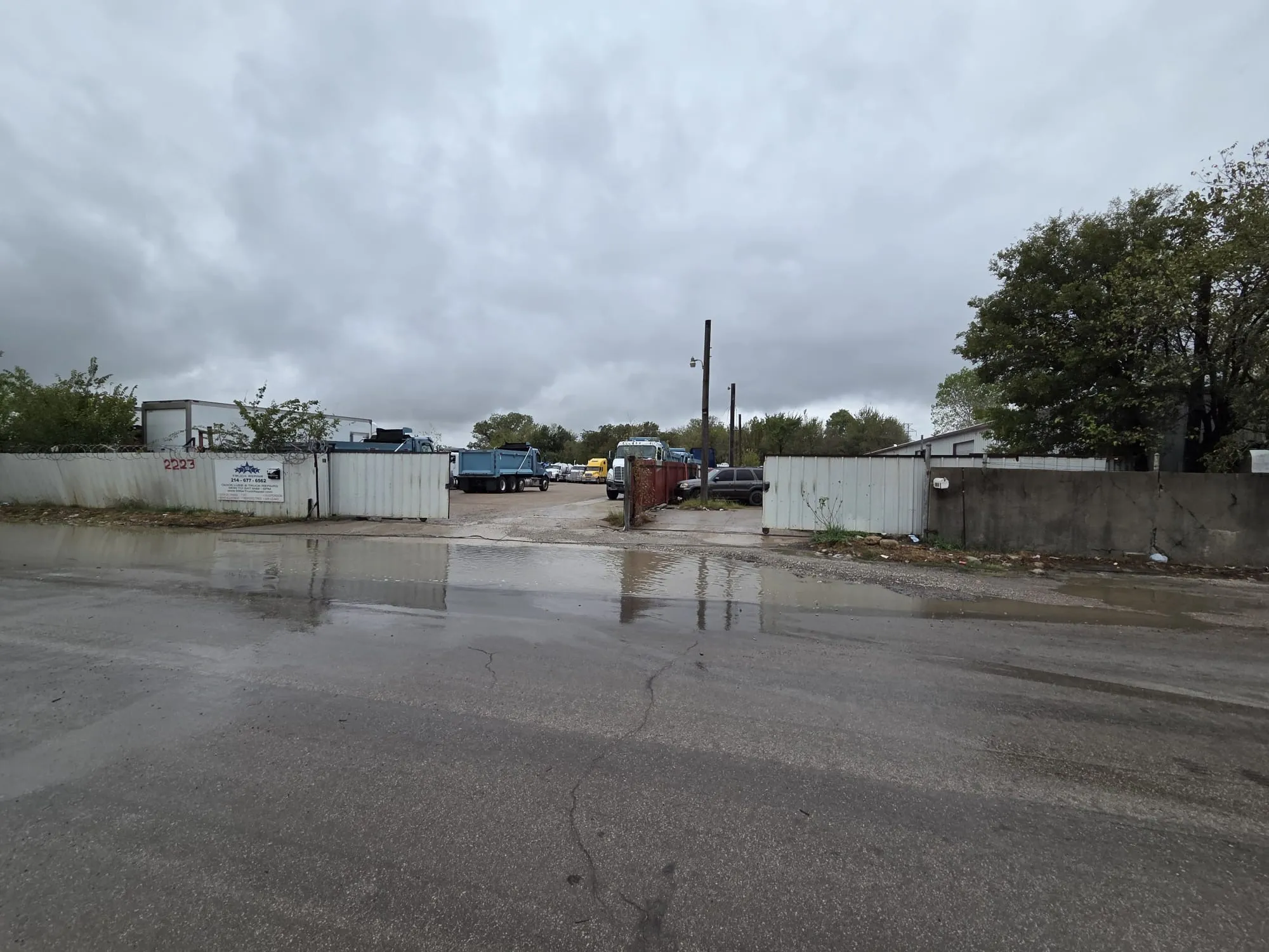 Industrial exterior lot featuring perimeter fencing, gated access, and an asphalt surface