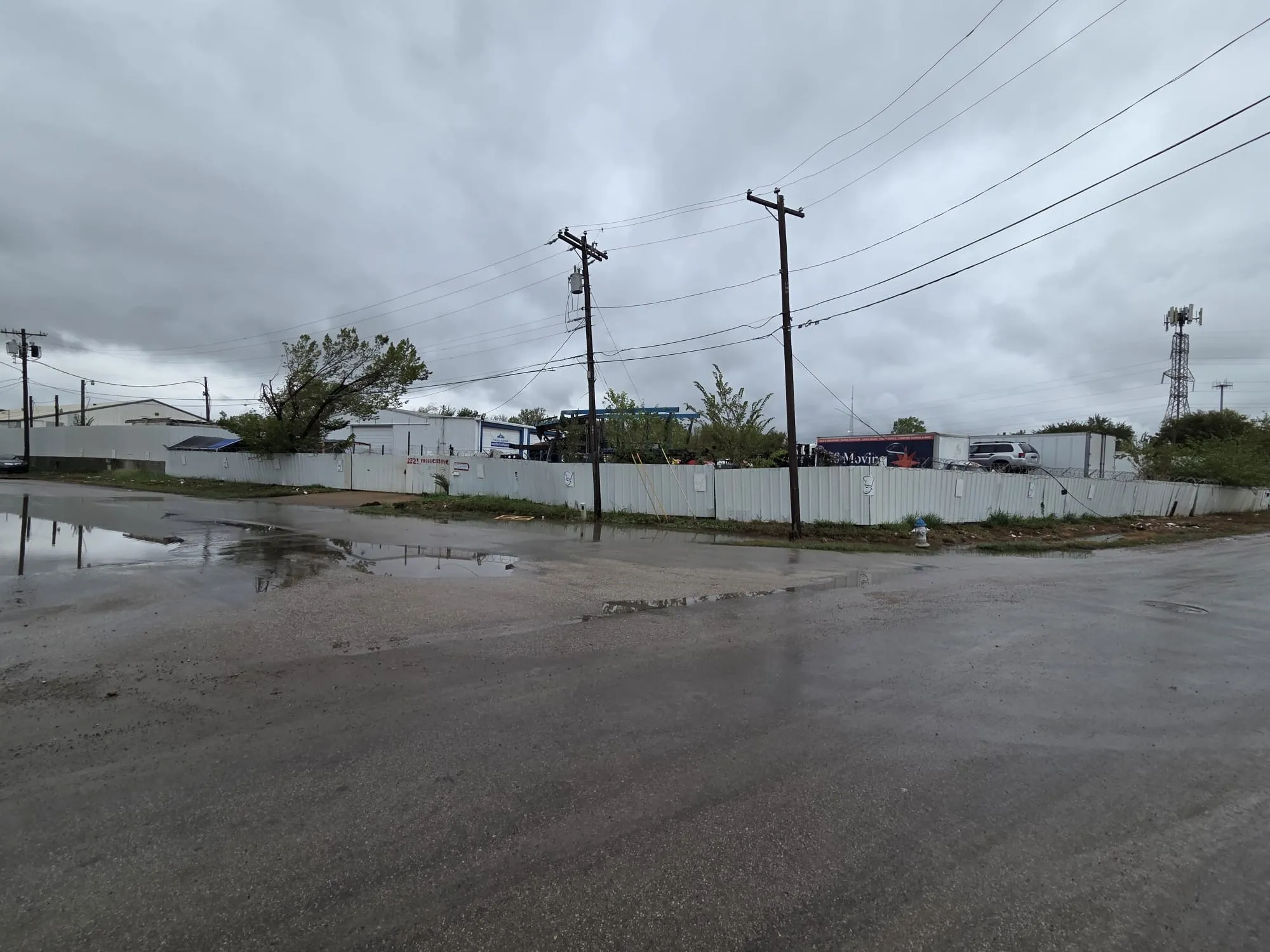 Exterior lot enclosed by perimeter metal fencing