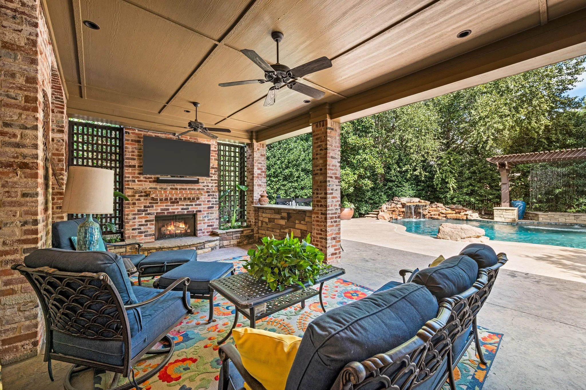 The inviting covered patio creates the perfect outdoor retreat, featuring a built-in grill, bar, and cozy fireplace.
