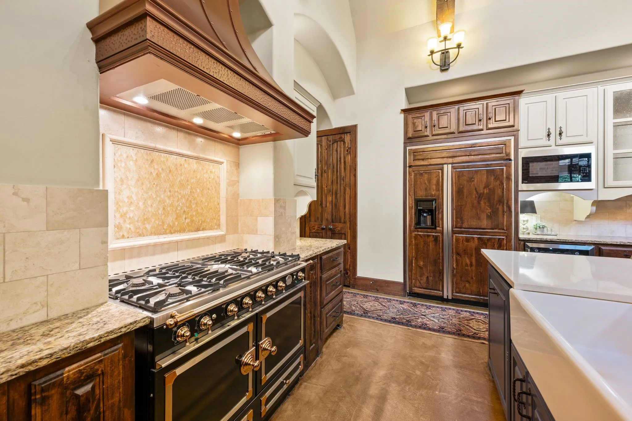 This beautifully appointed kitchen exudes luxury with premium appliances, a seamlessly integrated built-in refrigerator, and a spacious walk-in pantry offering exceptional storage and functionality.