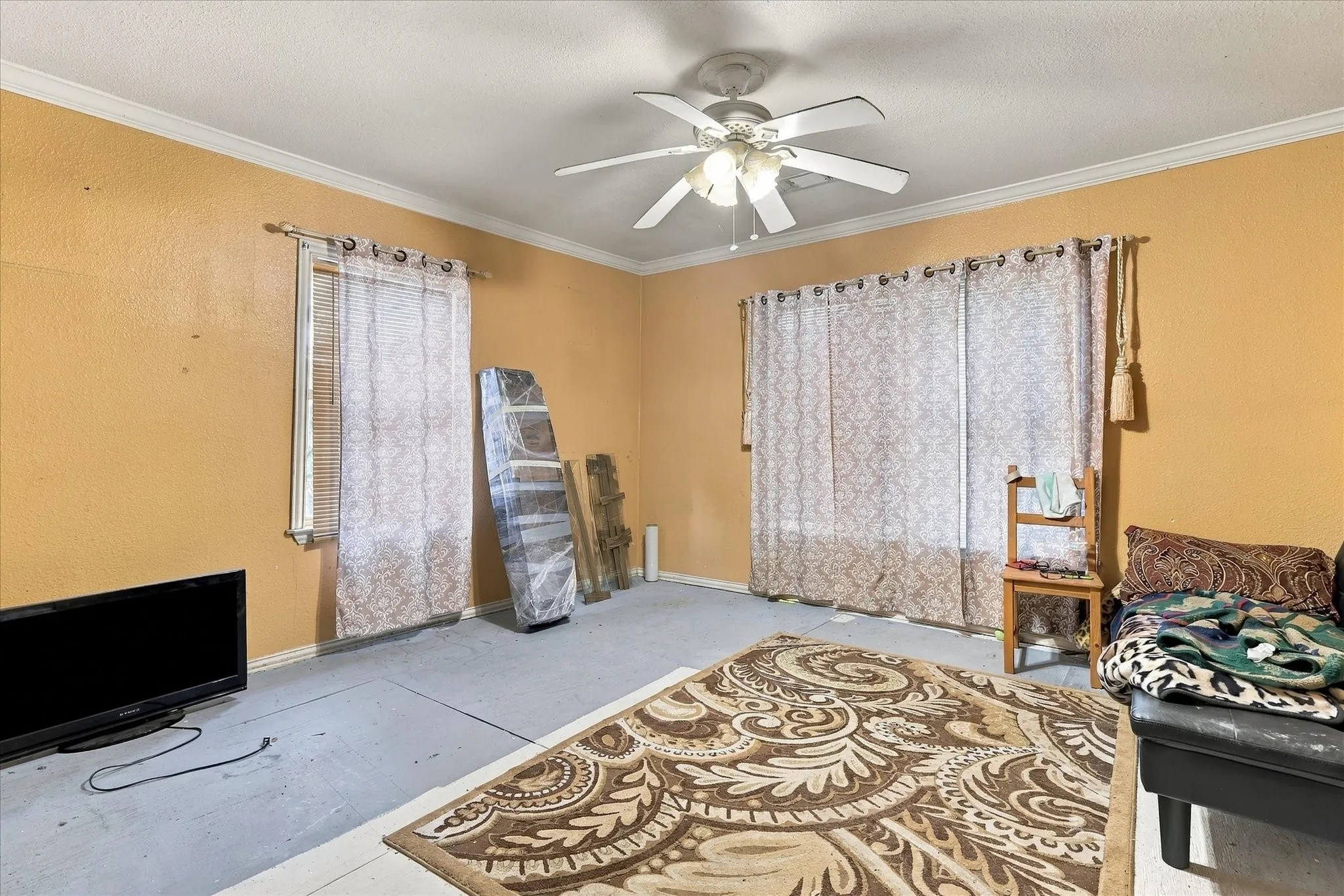Room featuring neutral wall tones, multi-pane window configurations, and a central ceiling fan with integrated lighting