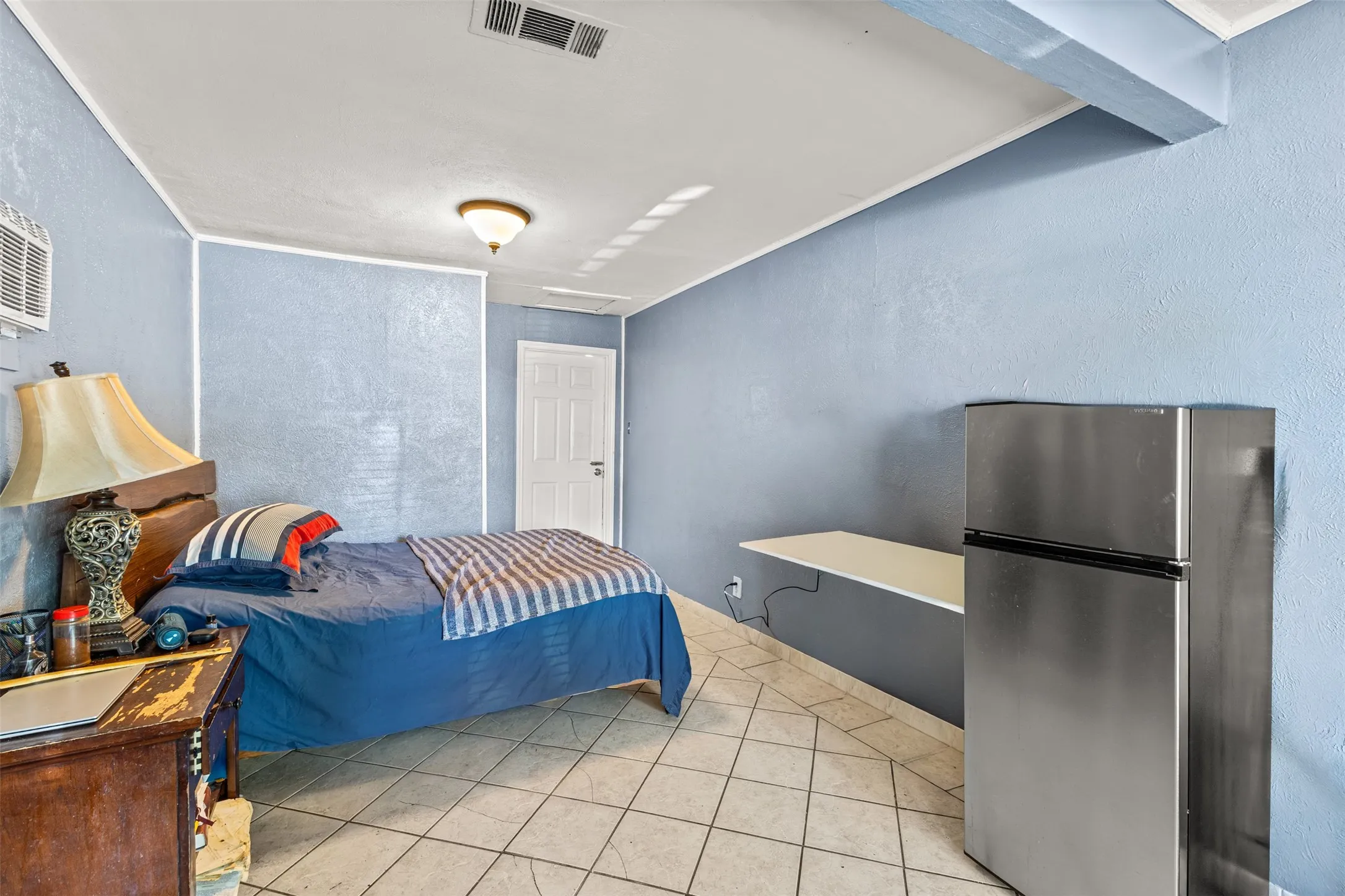 Interior space featuring diagonal ceramic tile flooring, a wall-mounted counter surface, and a single-panel interior door