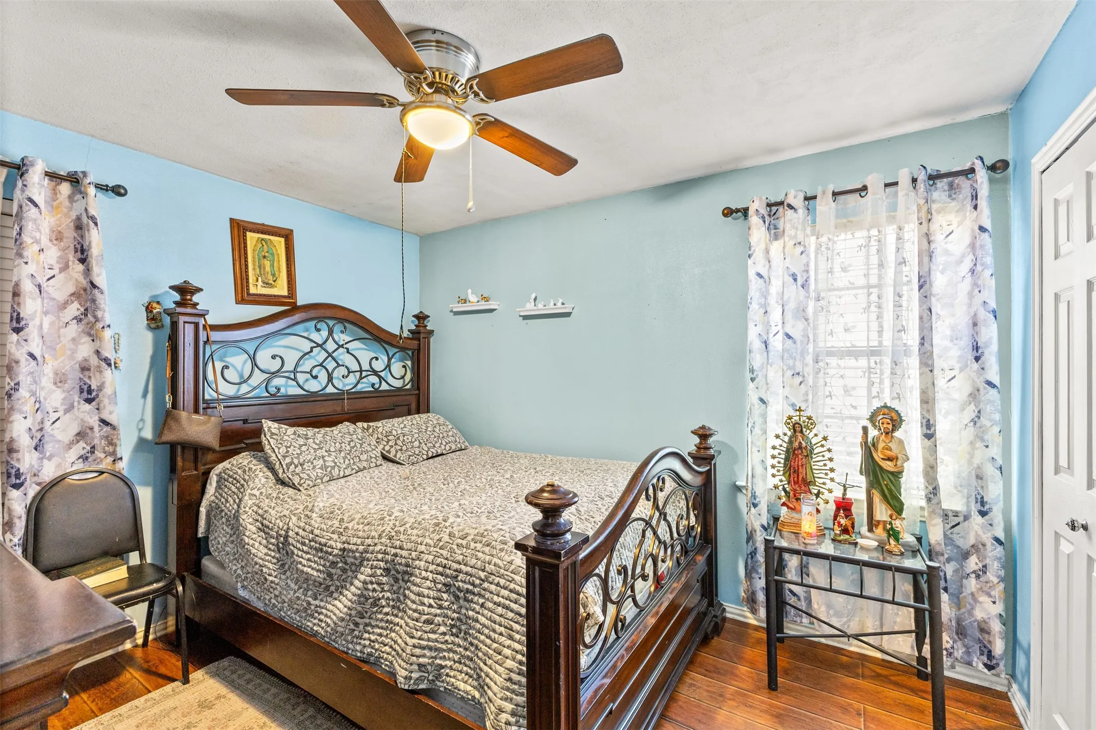 Wood-finish flooring, ceiling fan with integrated lighting, and white six-panel closet door