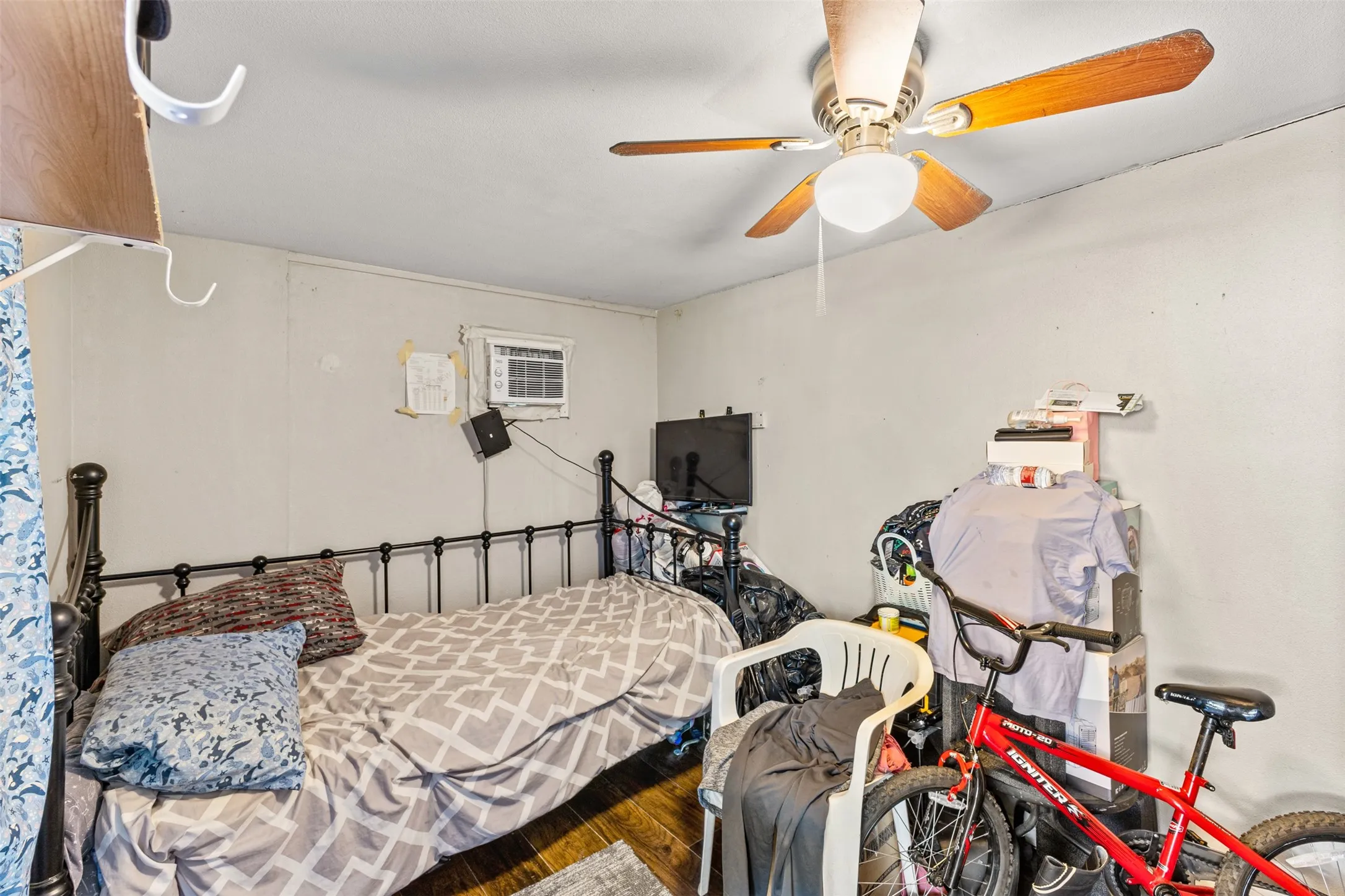 Interior room featuring wood-finish flooring and a central ceiling fan with integrated lighting