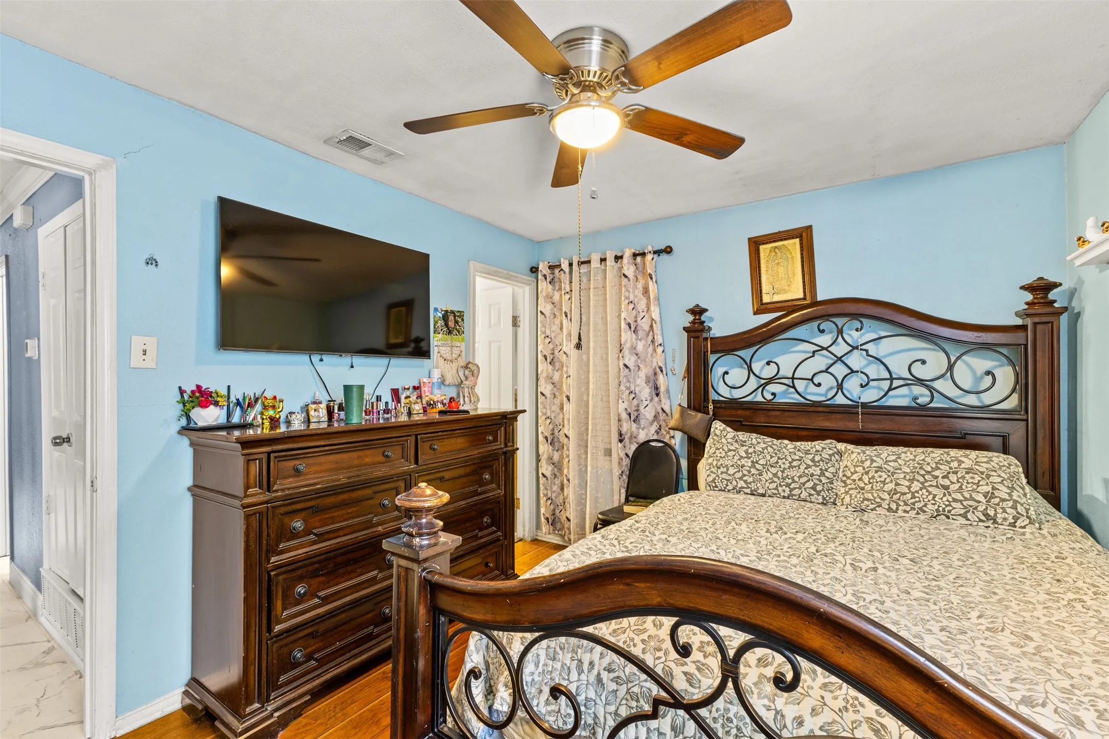 Interior room featuring wood-finish flooring and a central ceiling fan with an integrated light fixture