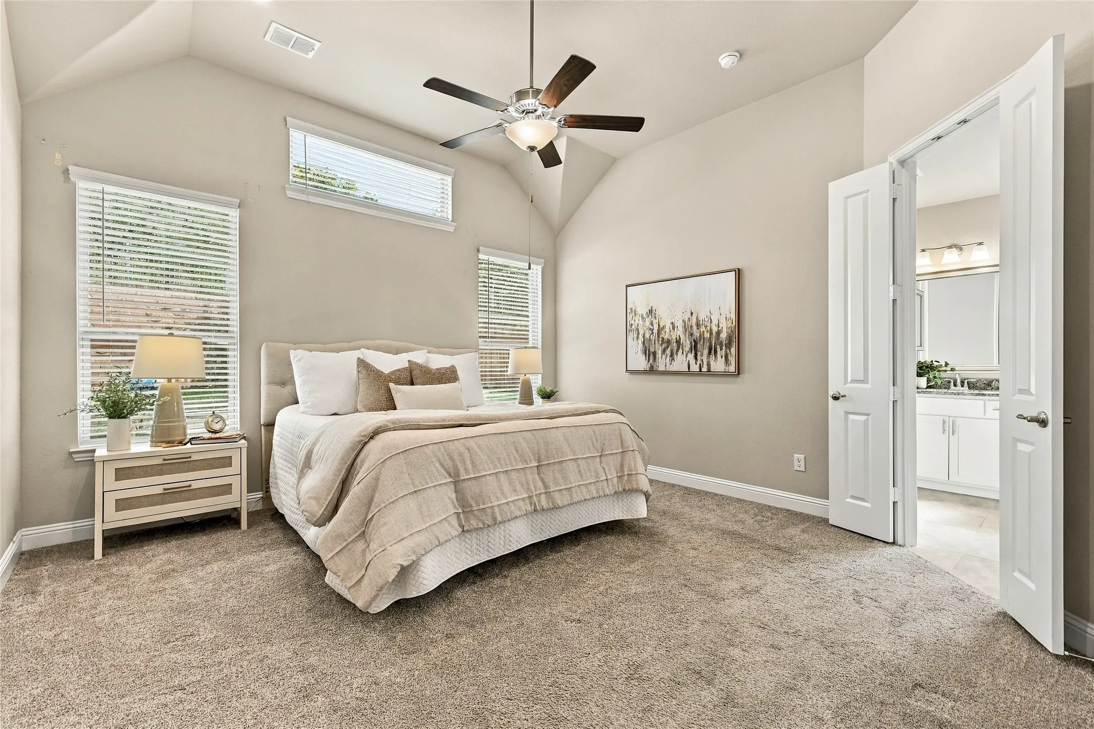 Vaulted ceiling, neutral wall tones, multi-pane window configuration, and overhead ceiling fan