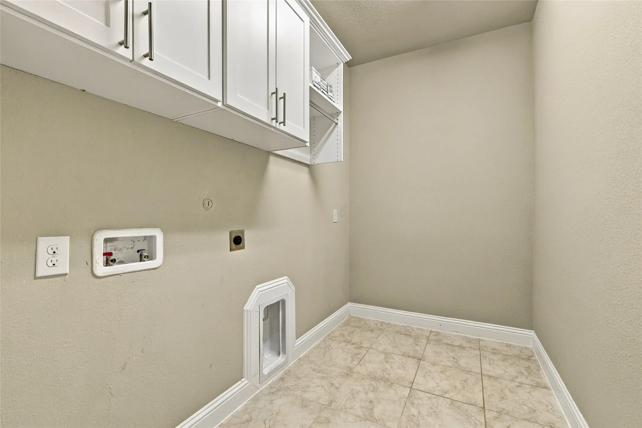 Utility area featuring white shaker-style cabinetry with modern bar hardware, an integrated laundry box, ceramic tile flooring, and a dedicated wall-mounted dryer vent