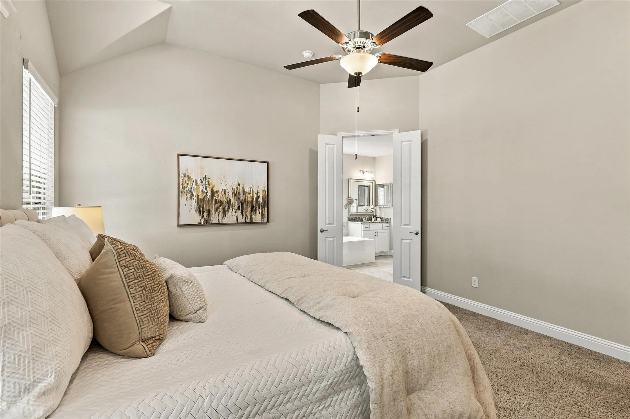 Vaulted ceiling featuring a central five-blade ceiling fan, wall-to-wall carpeting, and double-door entry