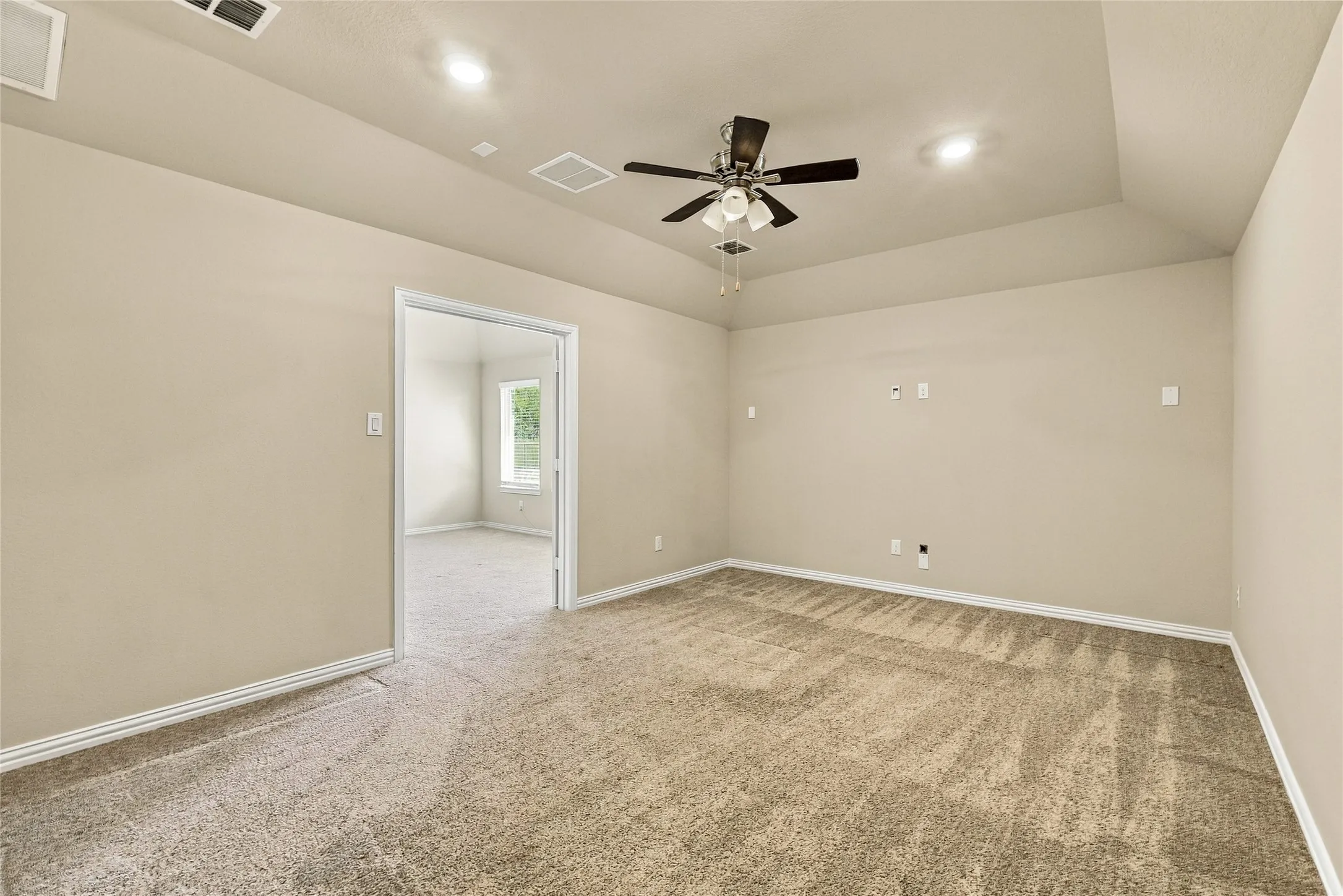 Tray ceiling with recessed lighting, carpeted flooring, and a central ceiling fan