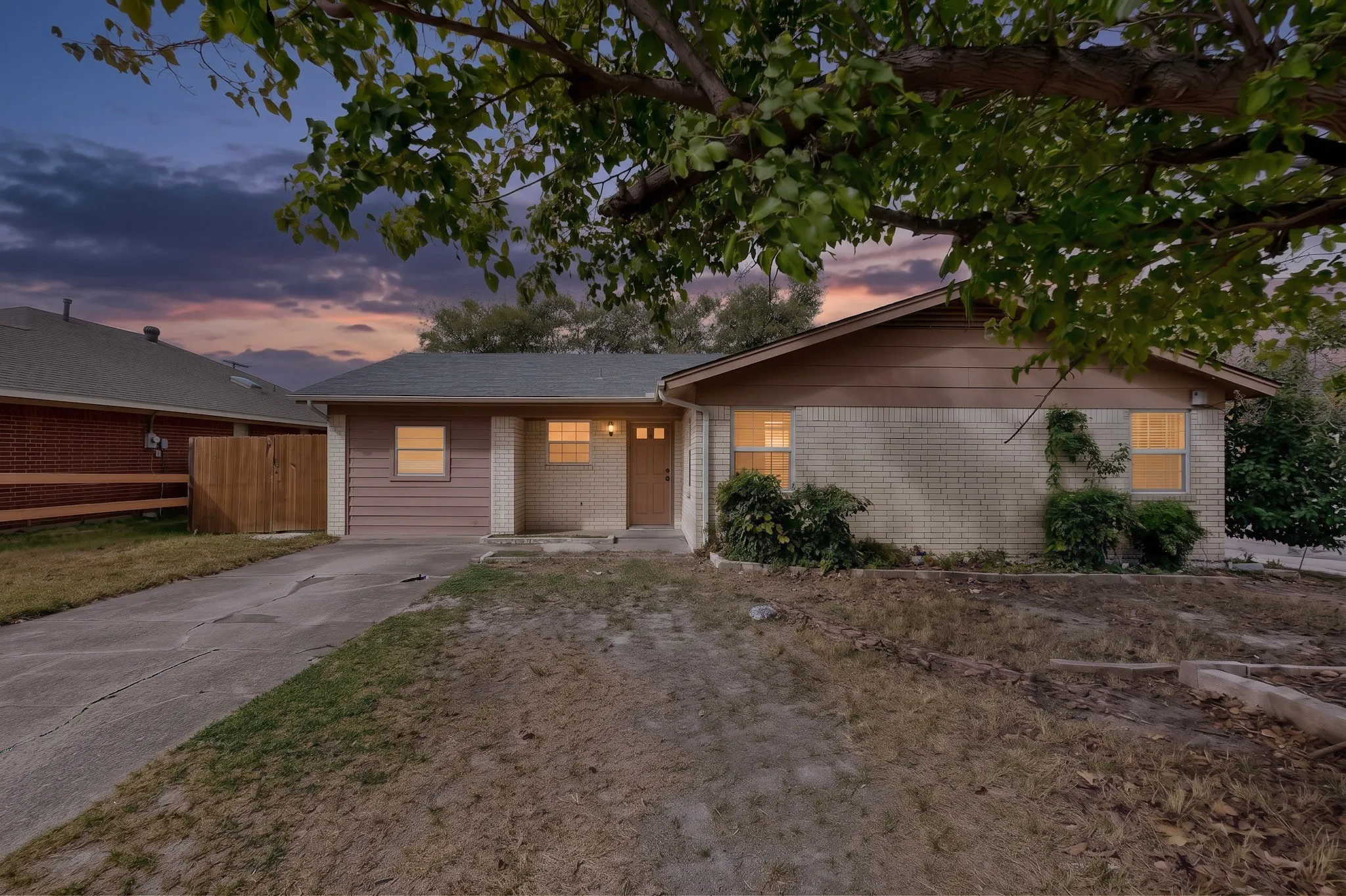 Single-story exterior featuring a brick and horizontal siding facade, a paved driveway, and an attached front entry
