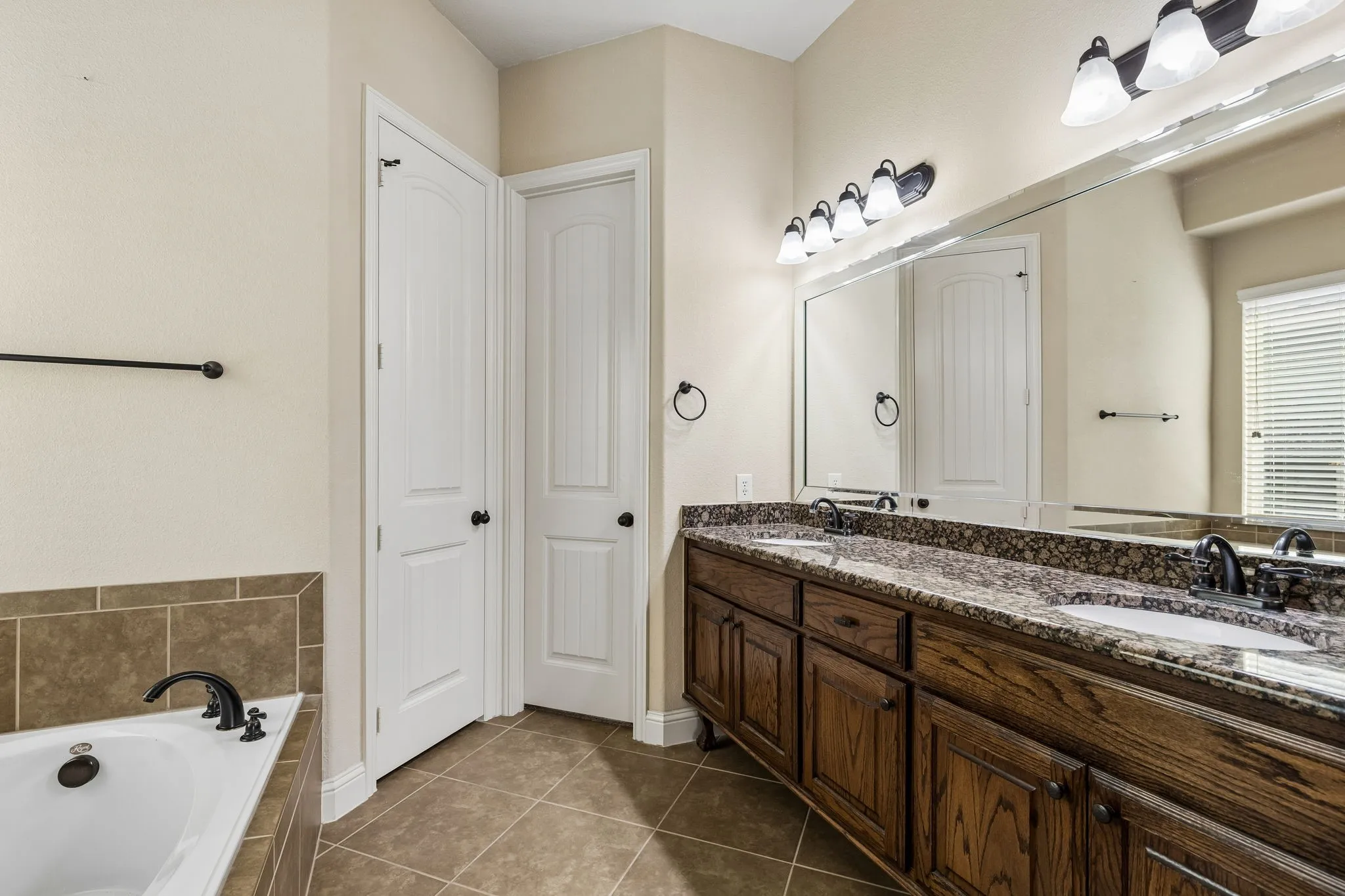 Dual-sink vanity with stone-finish countertop, undermount sinks, and oil-rubbed bronze faucets
