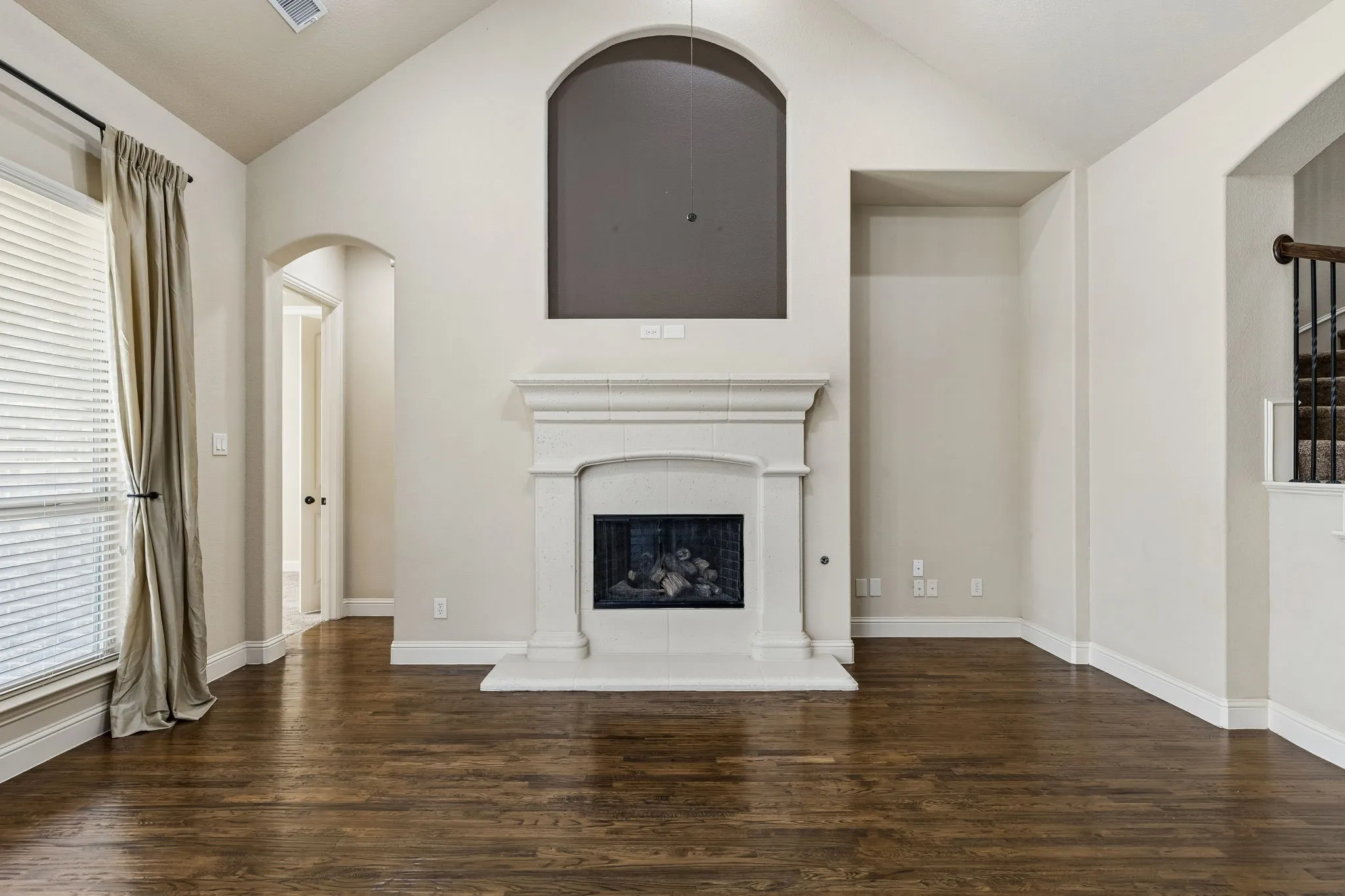 Vaulted ceilings, wood-finish flooring, and a fireplace with a custom mantel