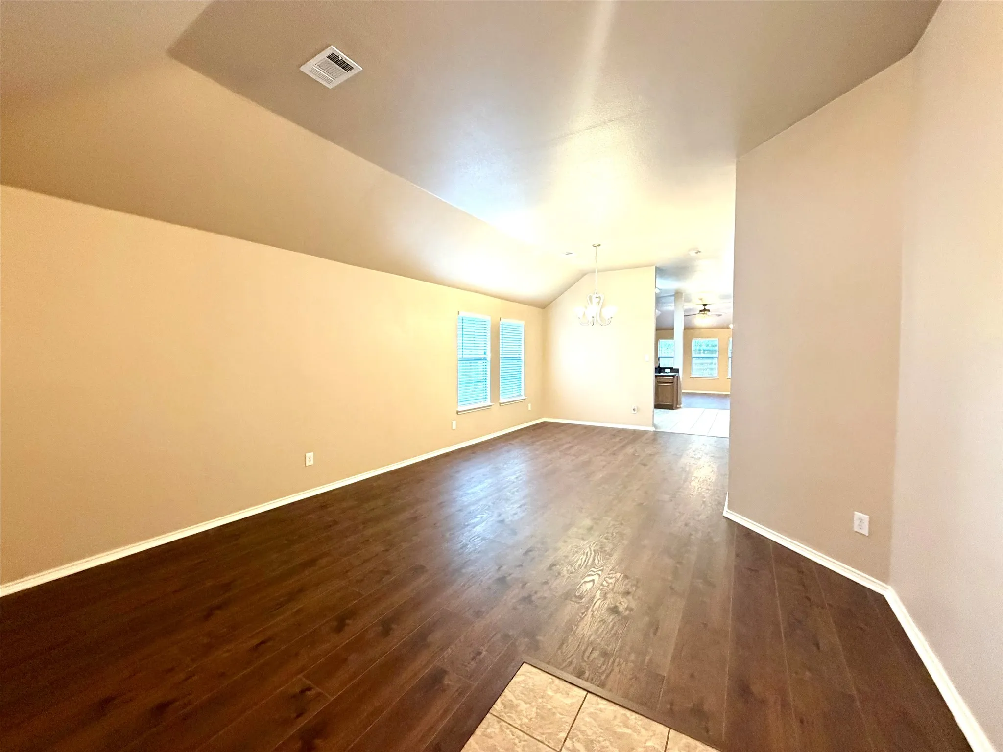 This spacious, light-filled living and dining area features a desirable open-concept floor plan that allows for seamless flow between rooms. The space is finished with durable, high-quality wood-look solid surface flooring throughout, combining the warm, aesthetic appeal of natural hardwood with the low-maintenance benefits of modern materials, perfect for both everyday comfort and sophisticated entertaining.