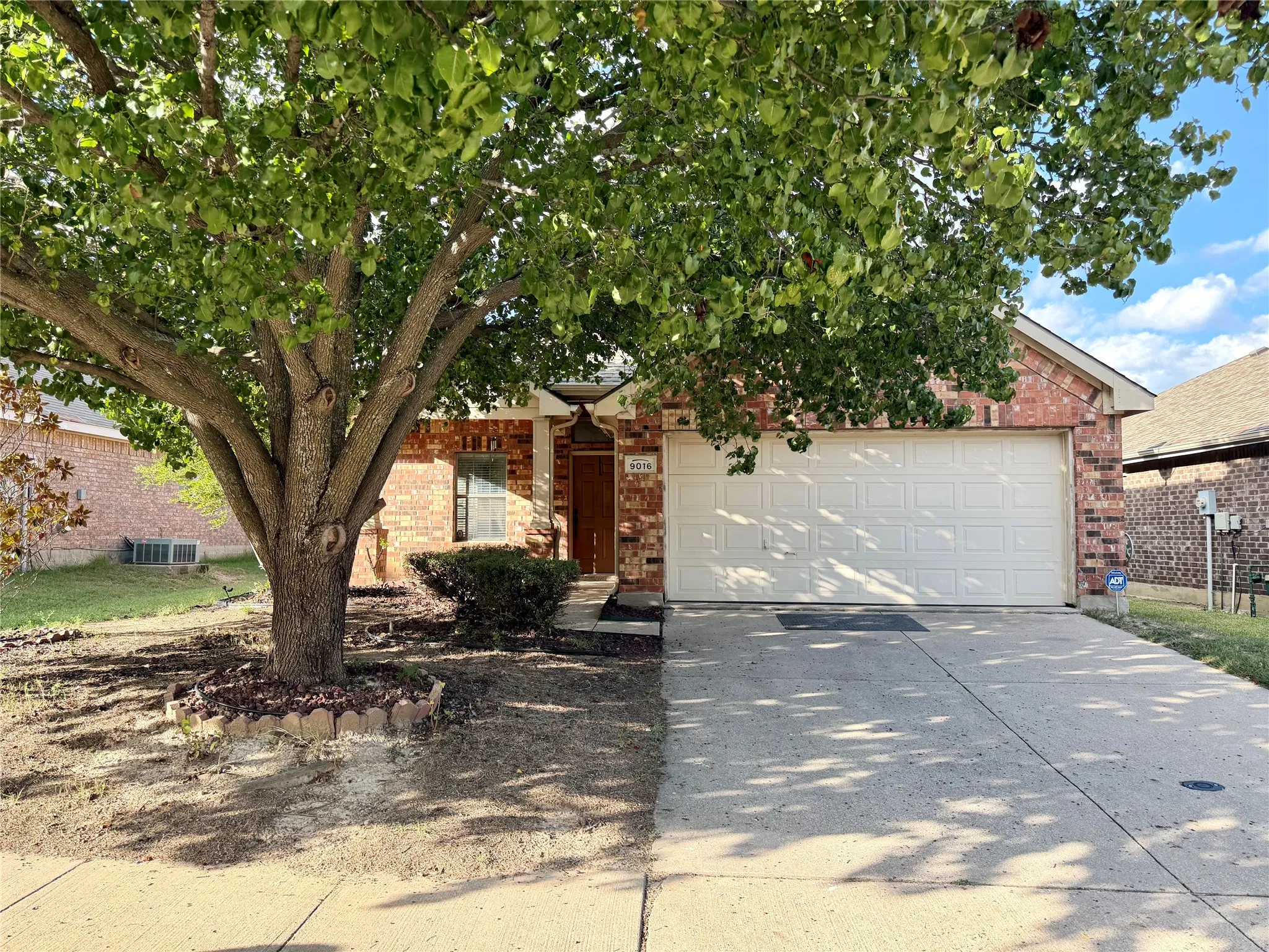 This stunning front exterior features classic, low-maintenance brick siding complemented by a  expansive concrete driveway that leads directly into a convenient two-car garage. The front yard is enhanced by a large, healthy, mature shade tree that provides excellent curb appeal, while the home's architecture is further defined by a welcoming front porch!