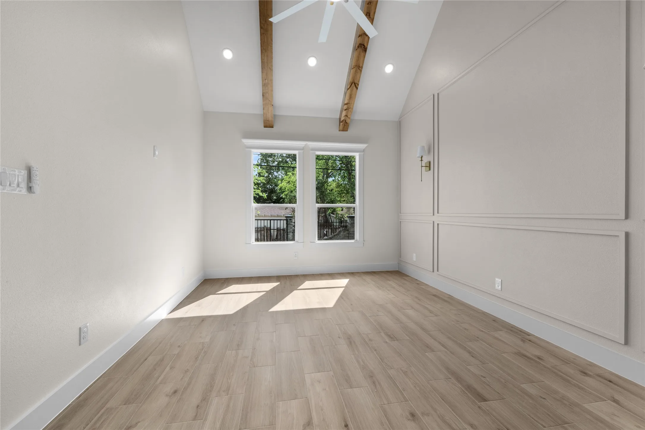 Vaulted ceiling featuring exposed wood beams, wall molding, wood-finish flooring, and recessed lighting