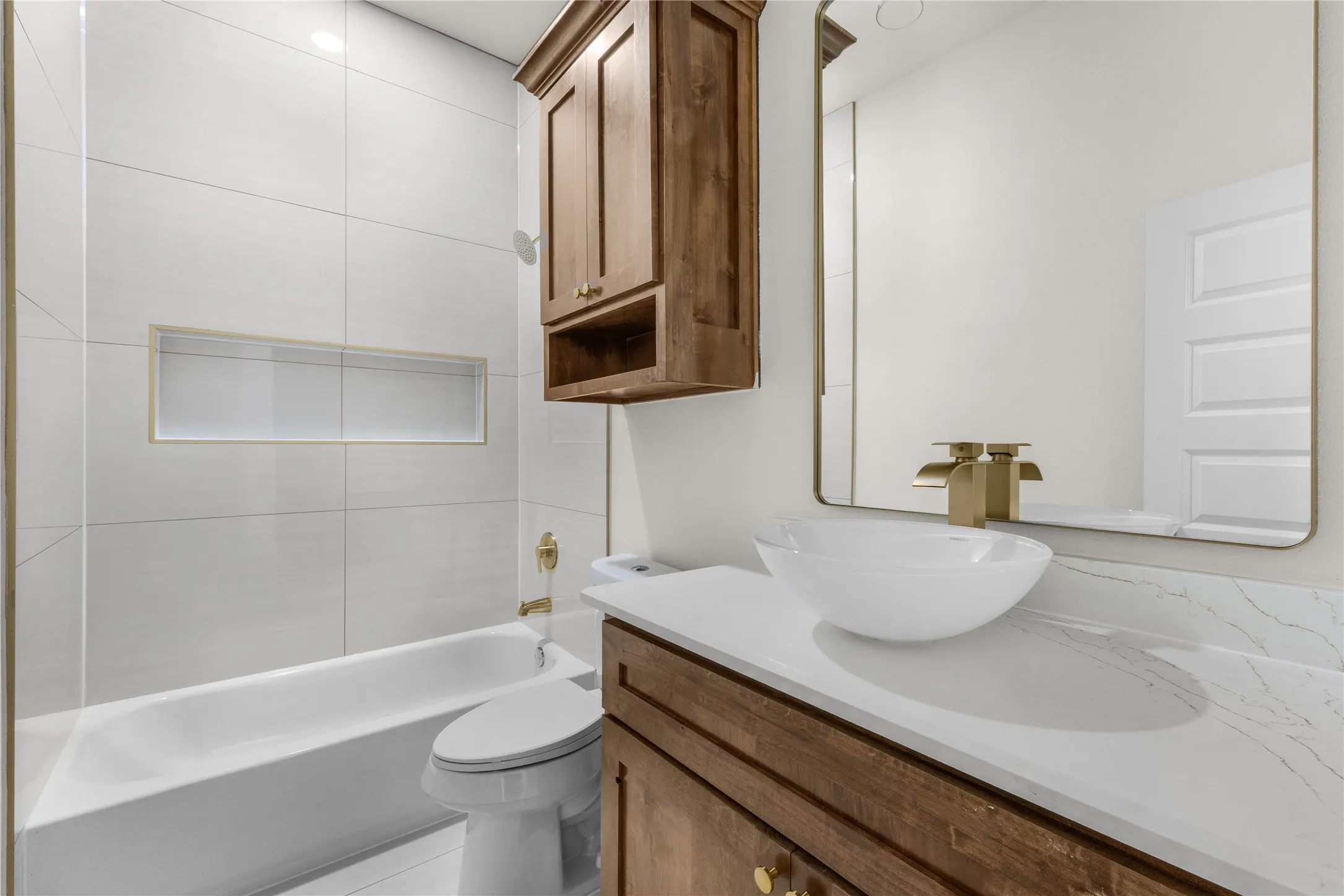 Bathroom featuring a vanity with wood-finish cabinetry, a white countertop, and a vessel sink