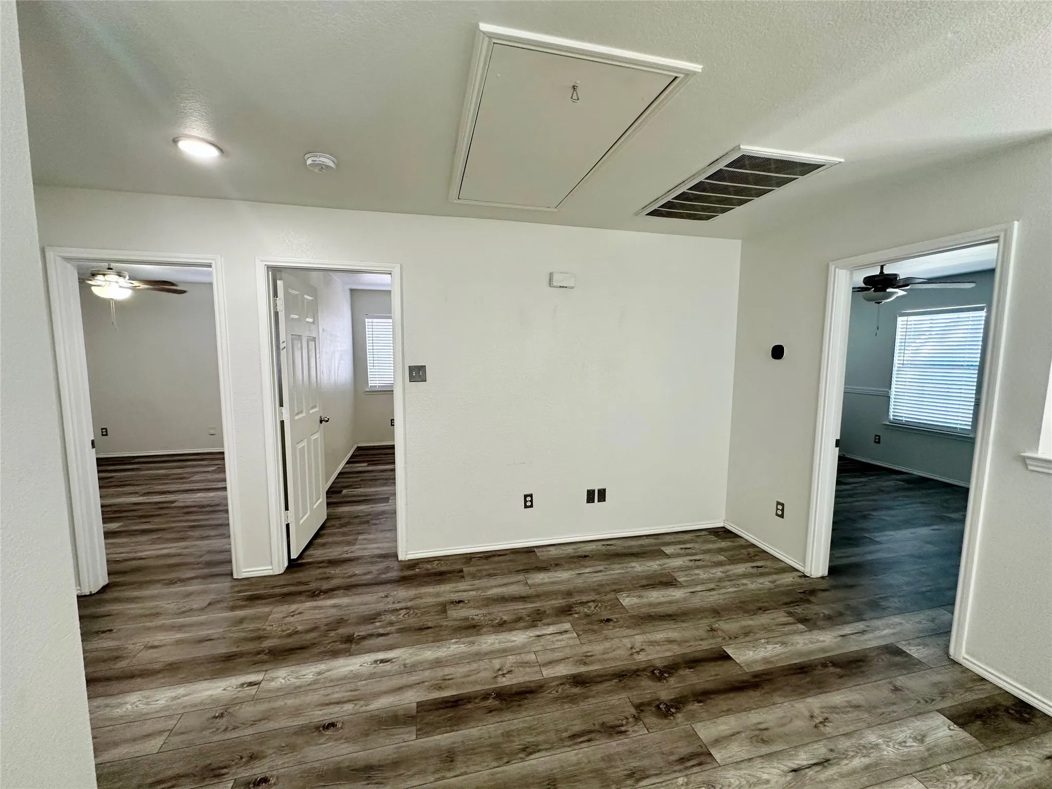 Interior space featuring wood-finish flooring, ceiling-mounted light fixtures, and multi-panel interior doors