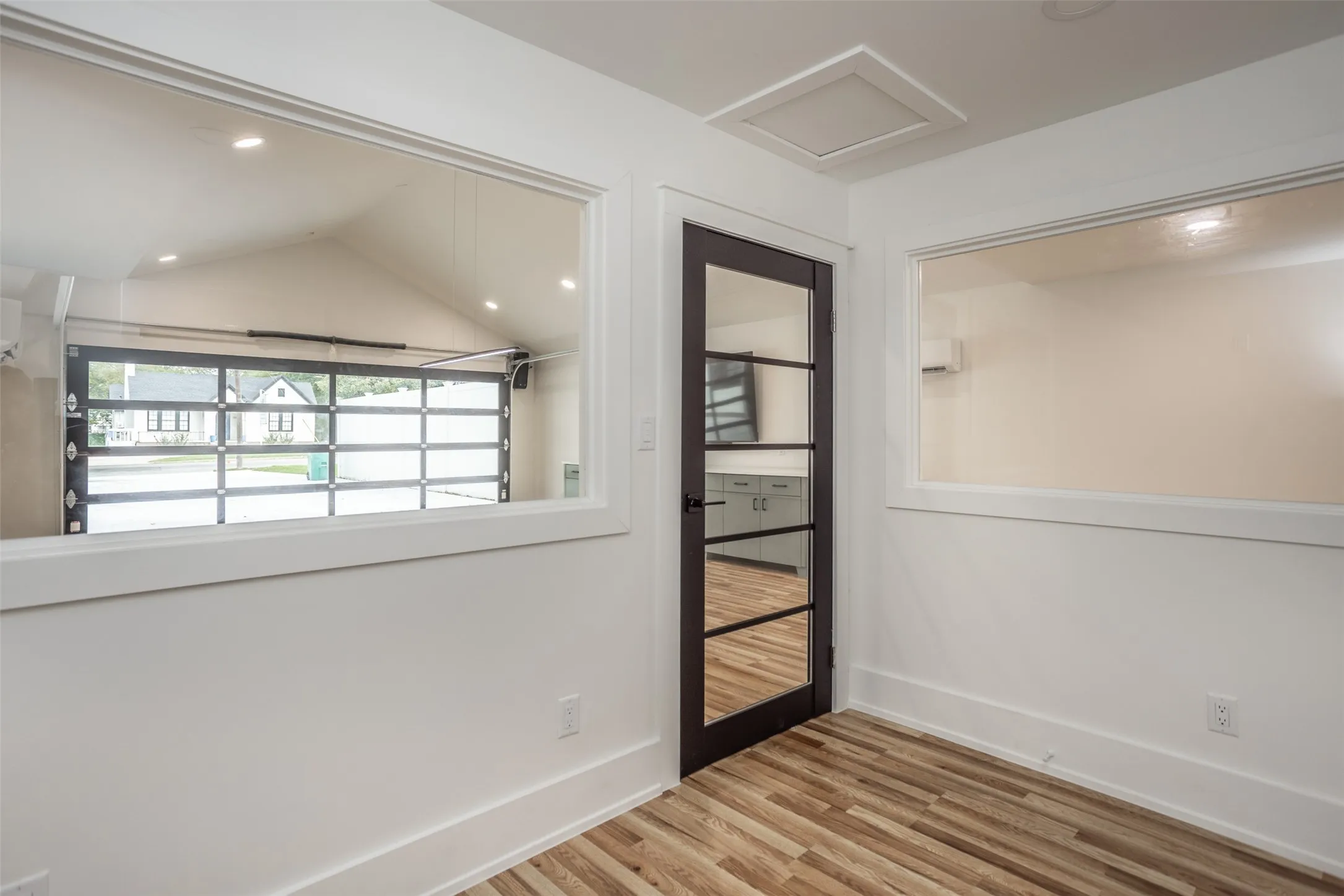 Interior space featuring wood-finish flooring, interior office, and a framed glass paneled door