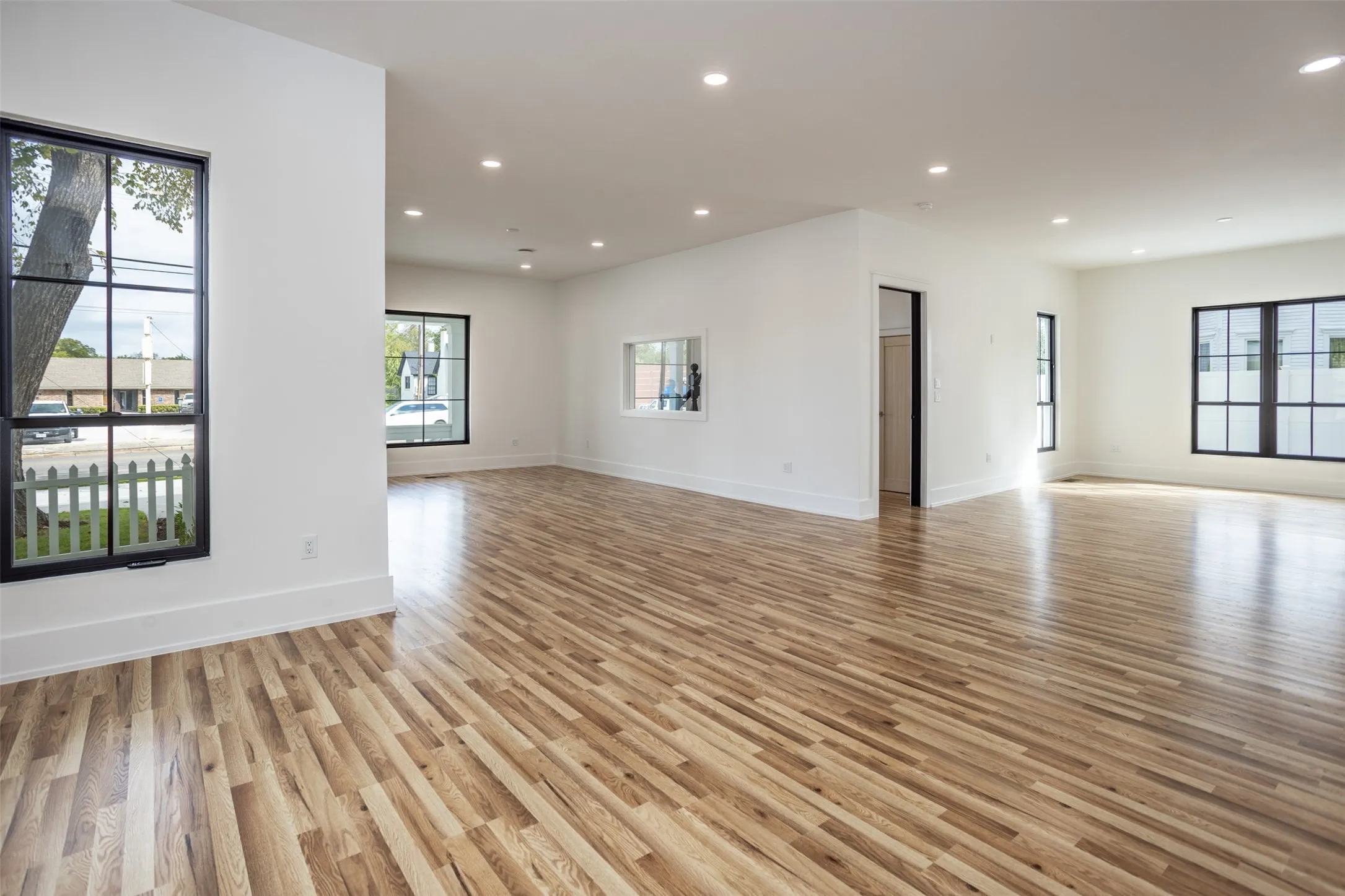 Open floor plan featuring wood-finish flooring, recessed lighting, and expansive windows