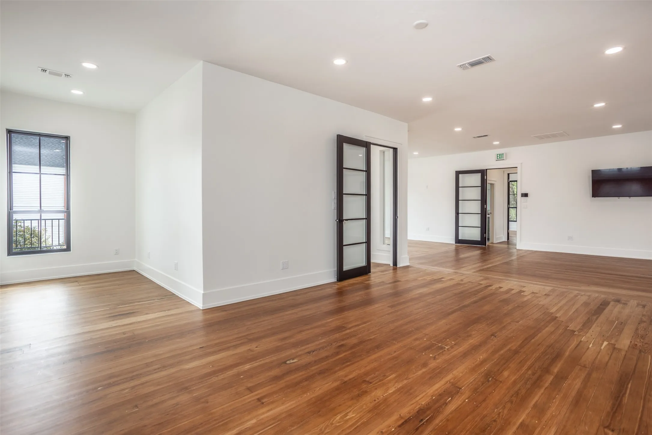 Wood-finish flooring, recessed lighting, and multi-pane glass doors