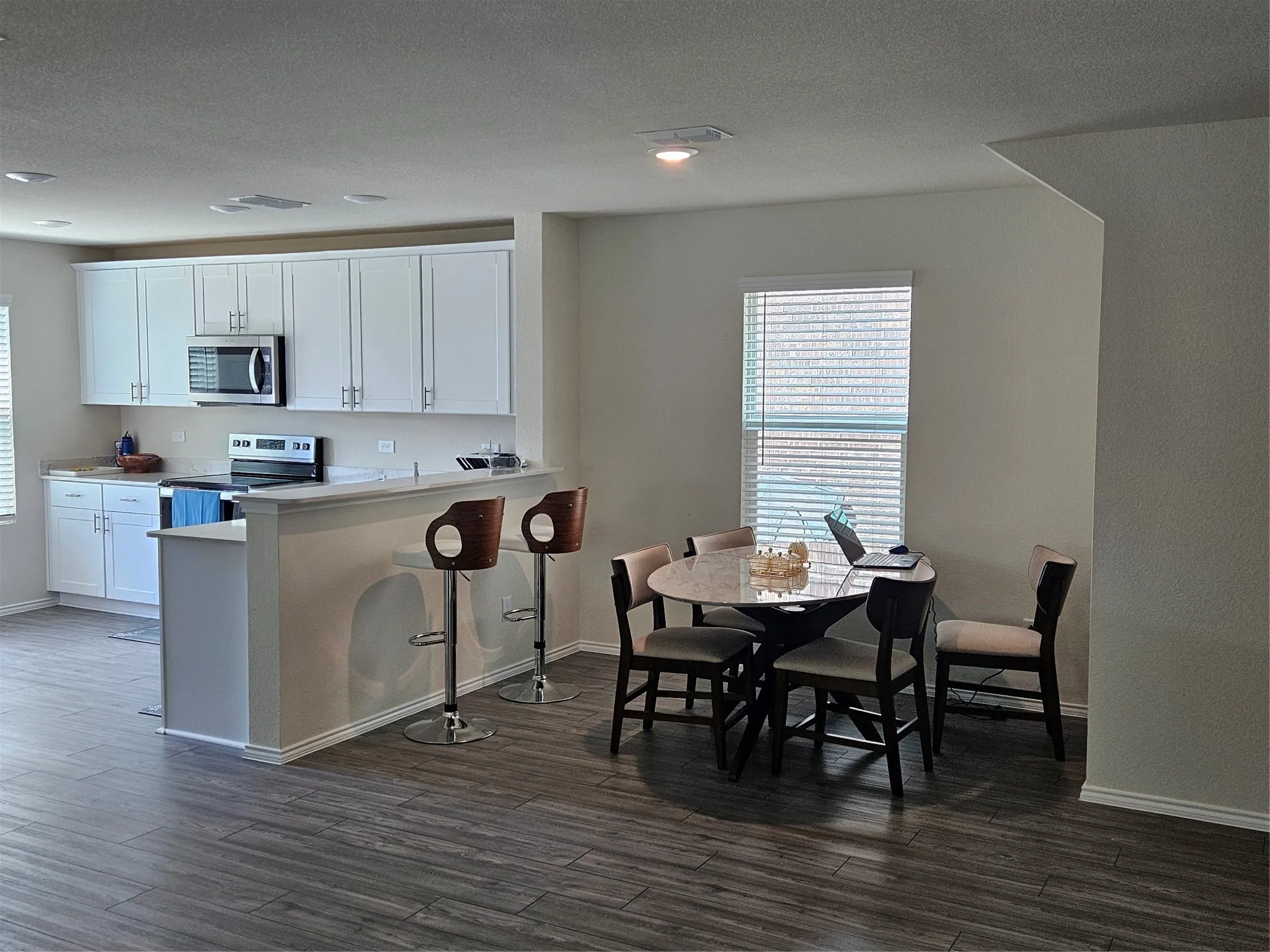 Kitchen featuring white cabinetry, stainless steel appliances, and a breakfast bar