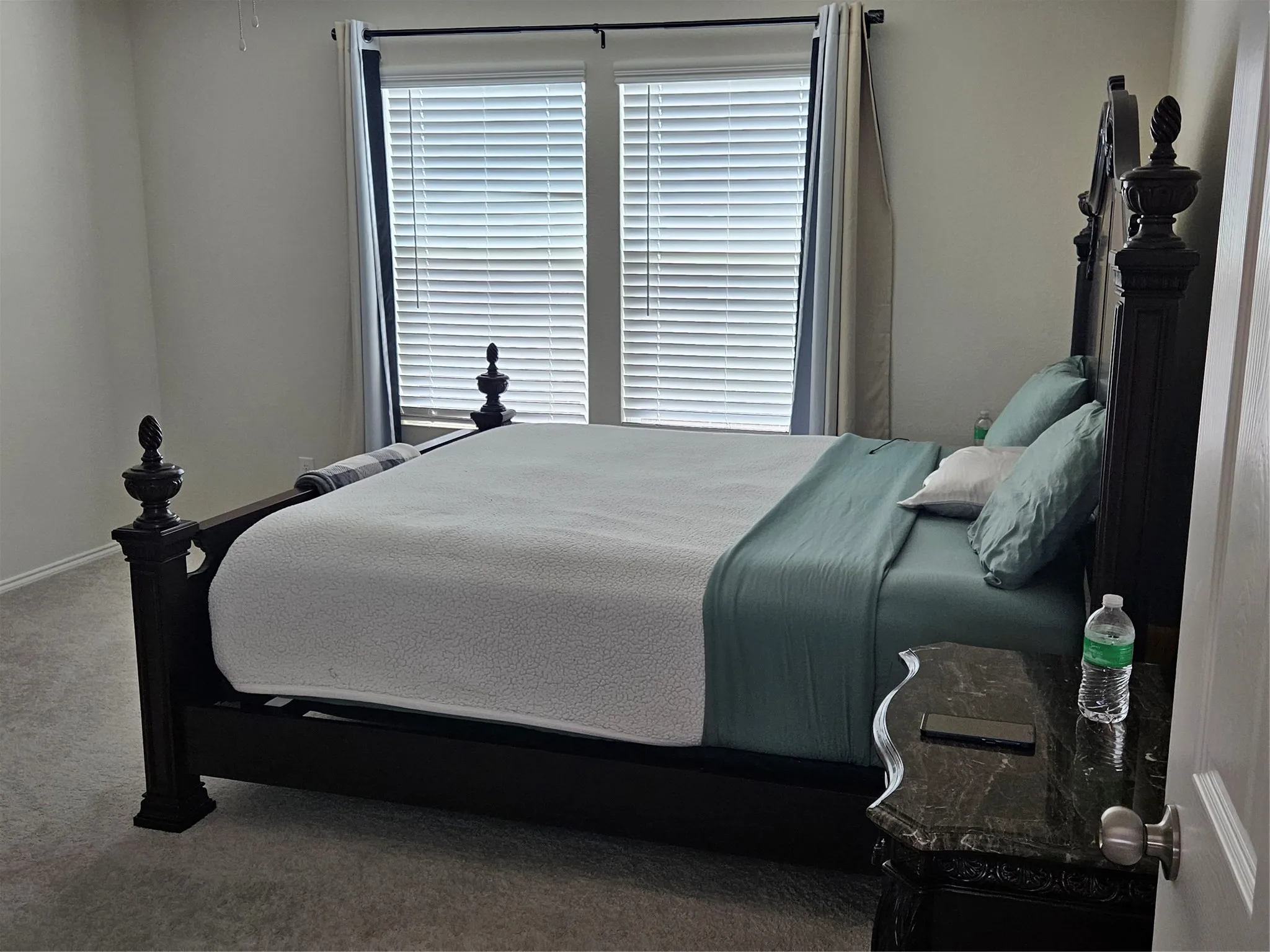 Neutral-toned carpeting, dual windows, and horizontal slat blinds
