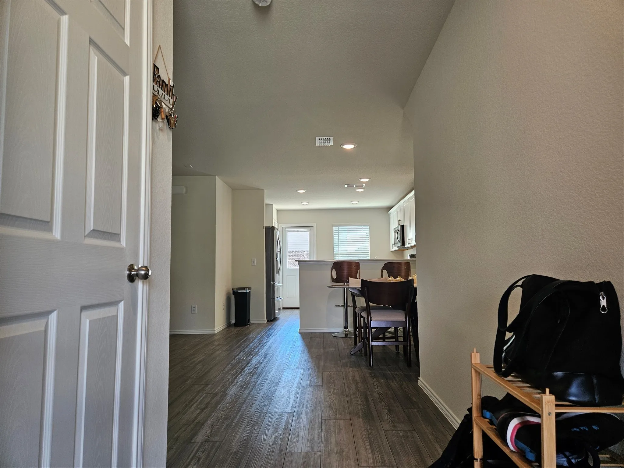 Interior featuring wood-finish flooring, recessed lighting, and a kitchen peninsula with a raised breakfast bar