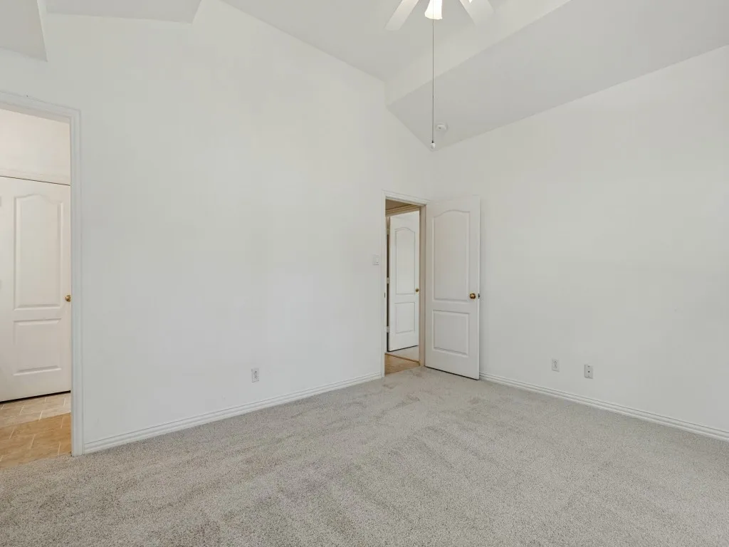 Vaulted ceiling, wall-to-wall carpeting, and interior arched-panel doors