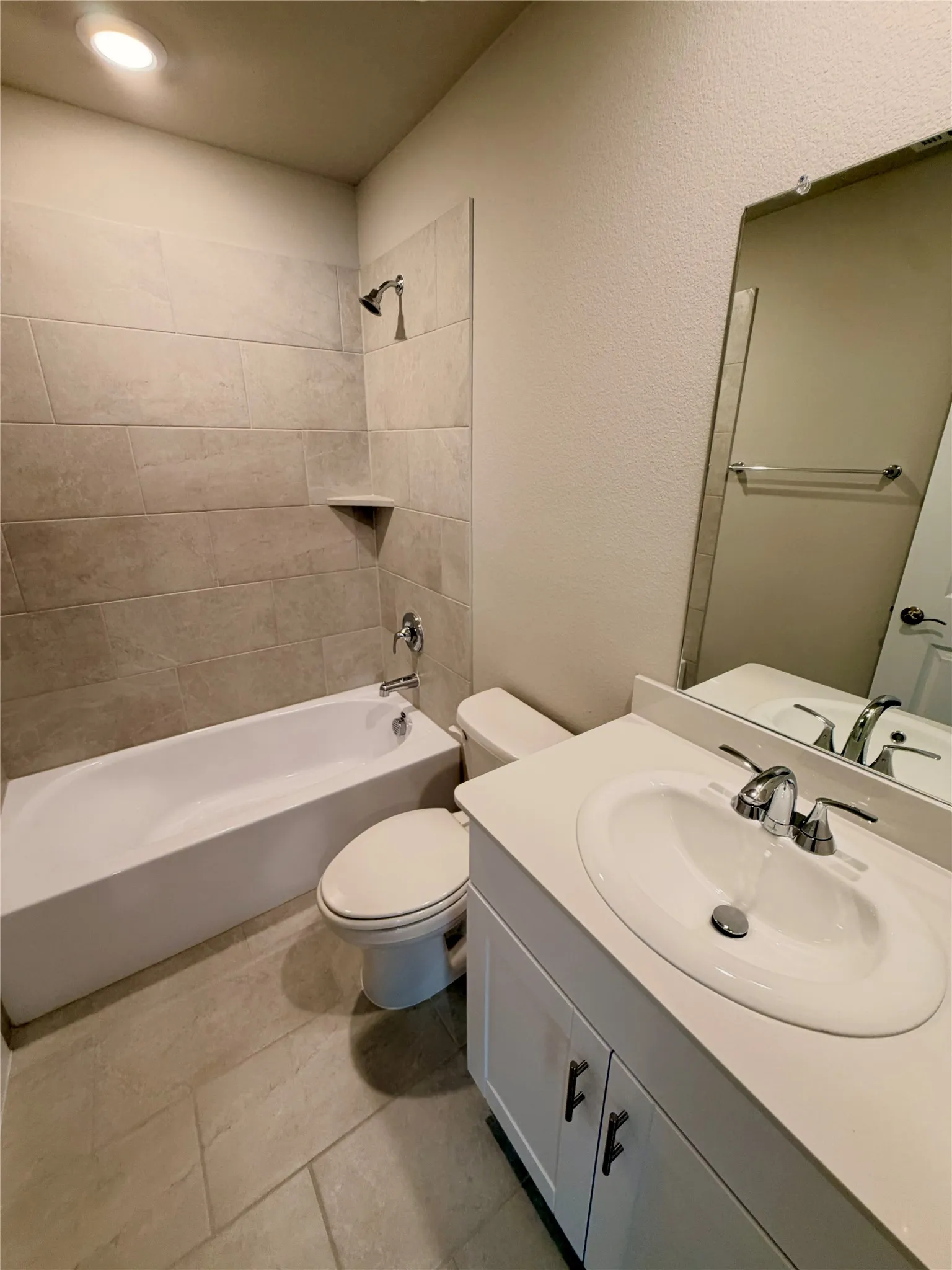 Bathroom featuring a vanity with a white solid-surface countertop, an integrated oval basin, and chrome fixtures