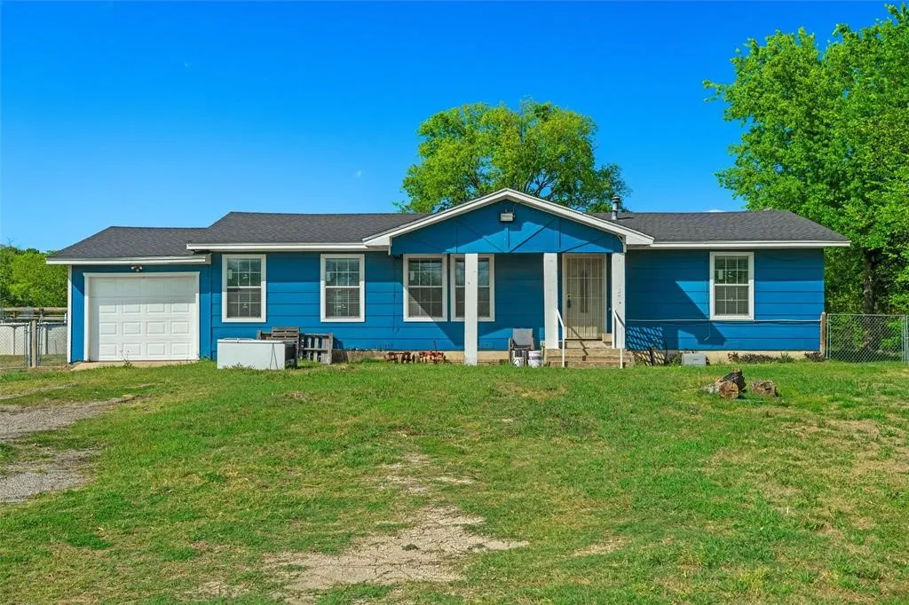 Single-story residence featuring blue horizontal siding, a central covered porch with structural columns, an attached one-car garage, and a gable roof