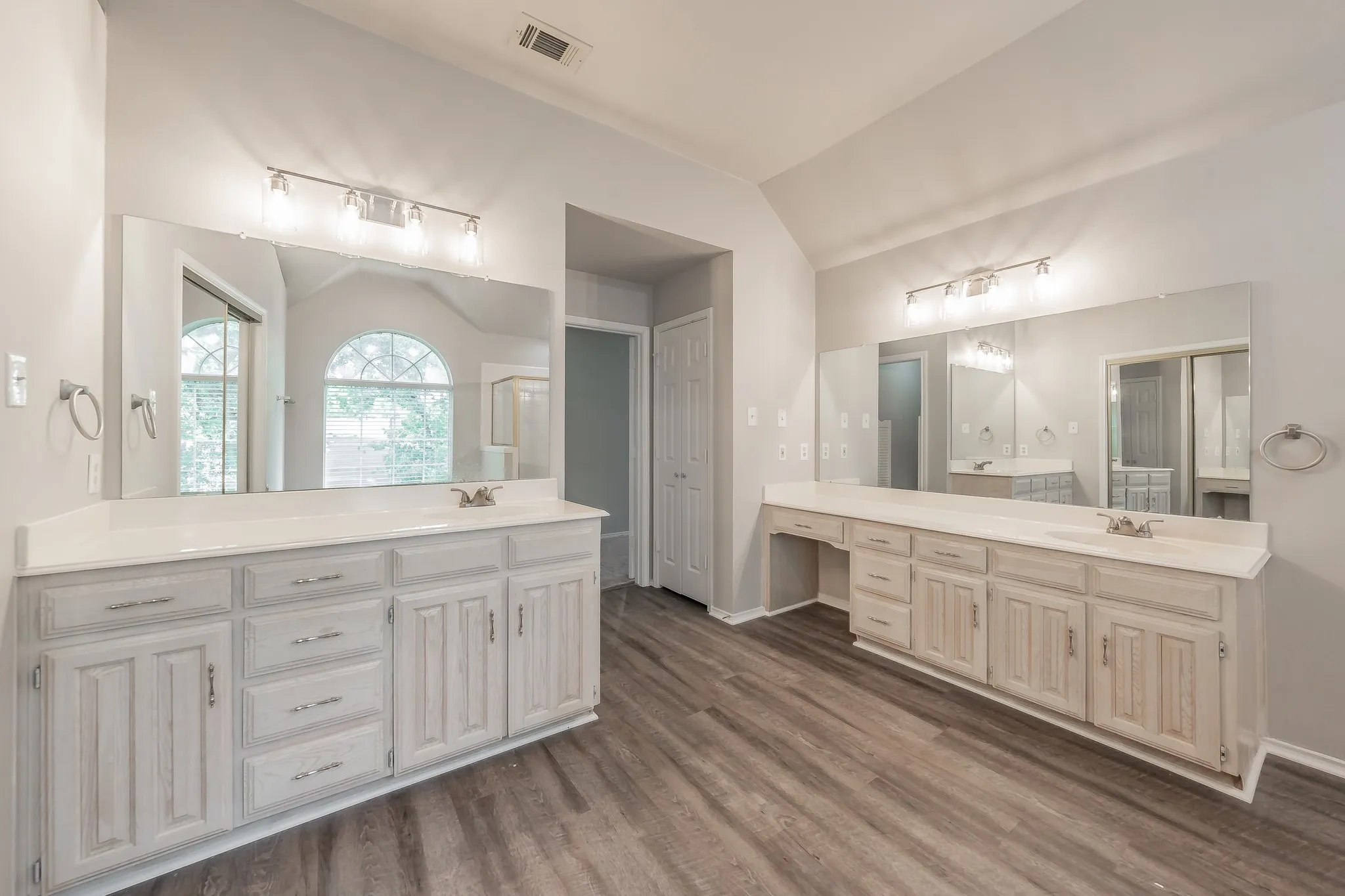 Dual vanities in spacious primary bathroom offering plenty of space for couples.