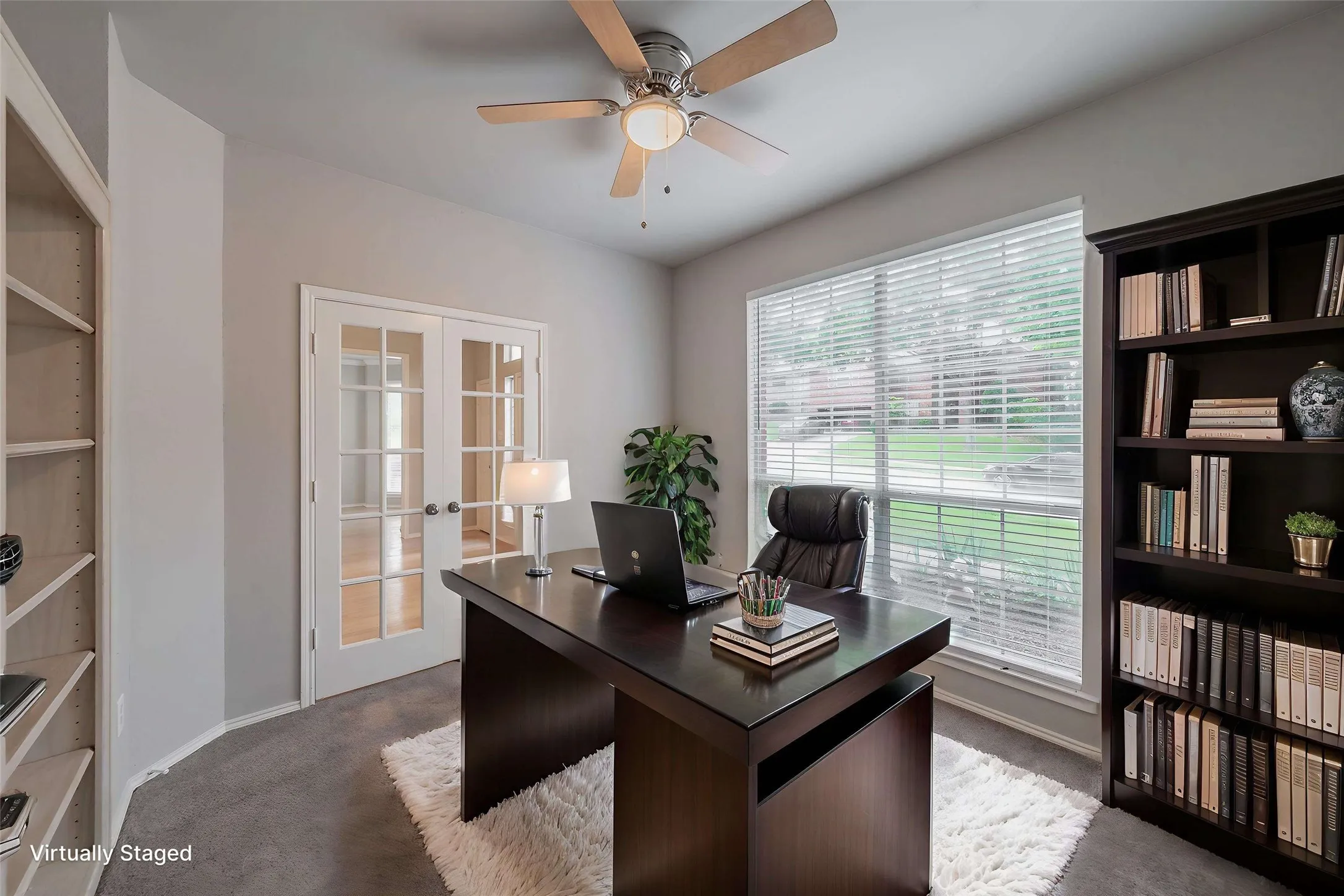 Virtually staged office with French doors and windows overlooking the front yard.
