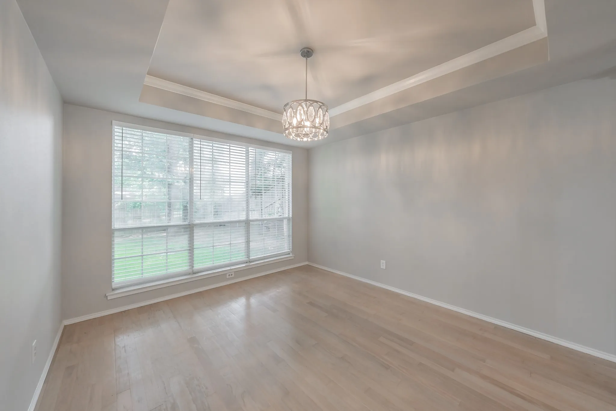 Beautiful hardwood floors and wall of windows offer plenty of natural light into formal dining room.