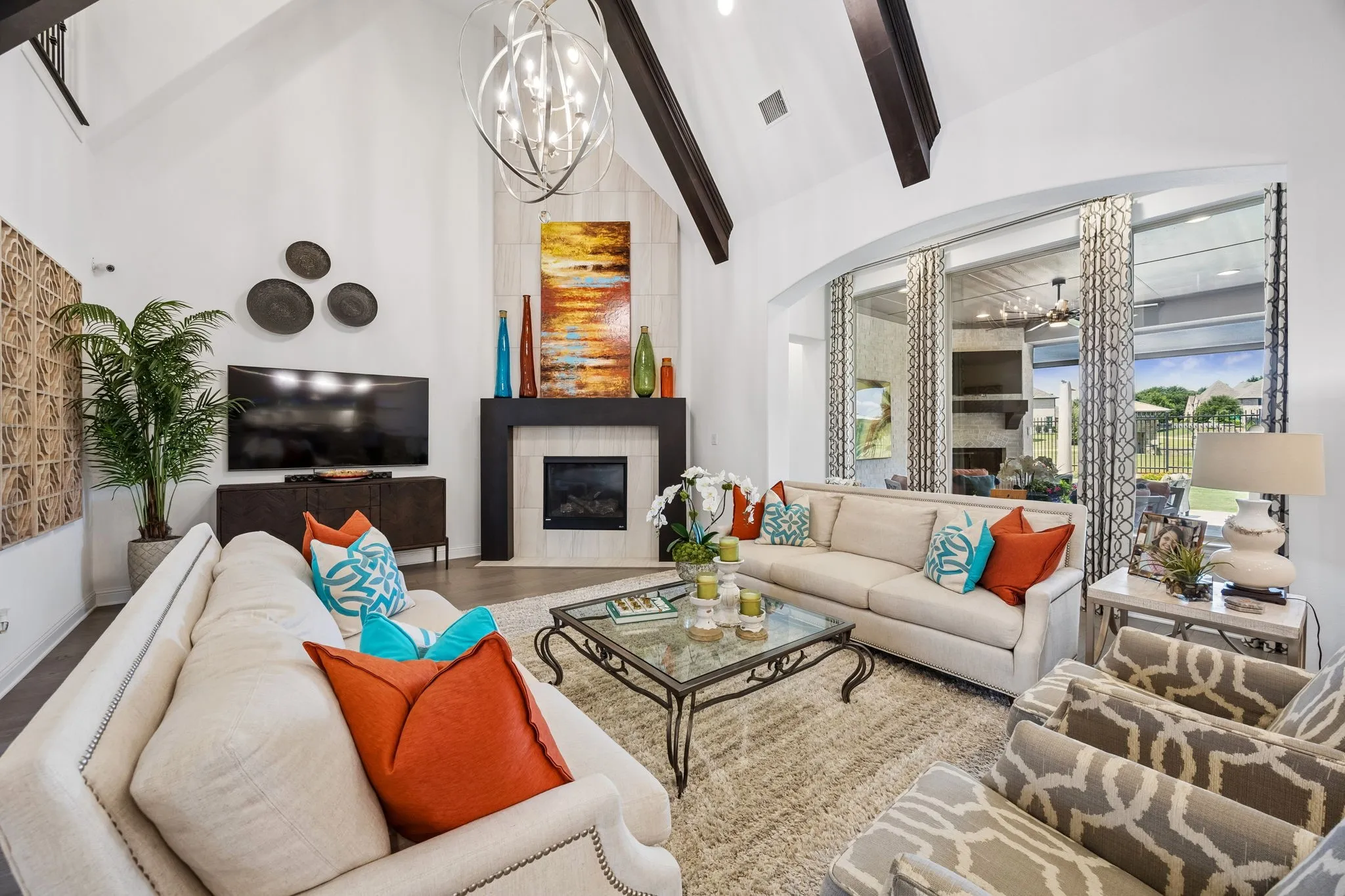 Oversized heart of the home family room with soaring beamed ceiling, stunning chandelier, and floor to ceiling fireplace all looking out to lake, fountain and greenbelt.