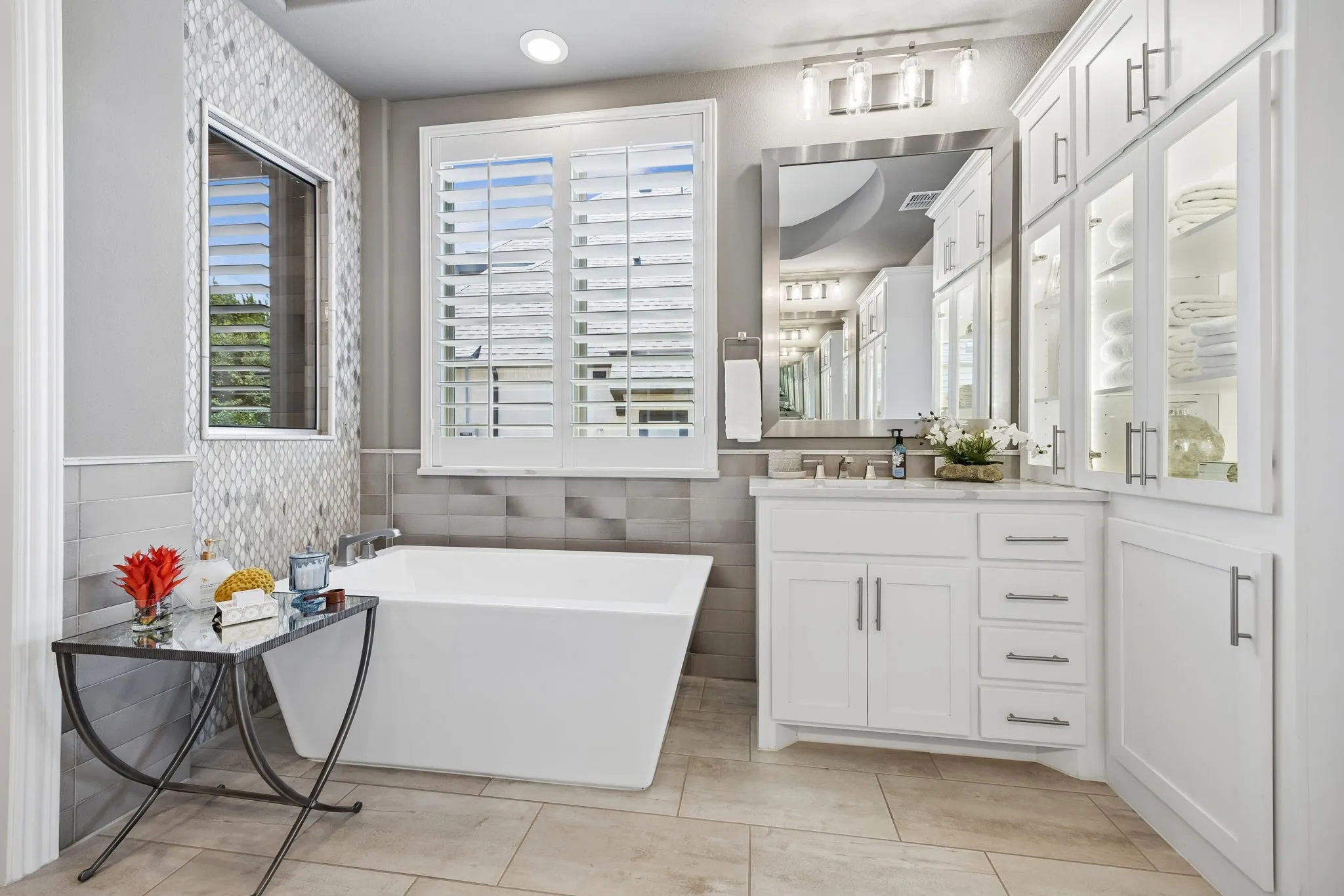Notice the stunning use of different tiles on the wall, floor, and shower exterior all designed by IBB Design Group.