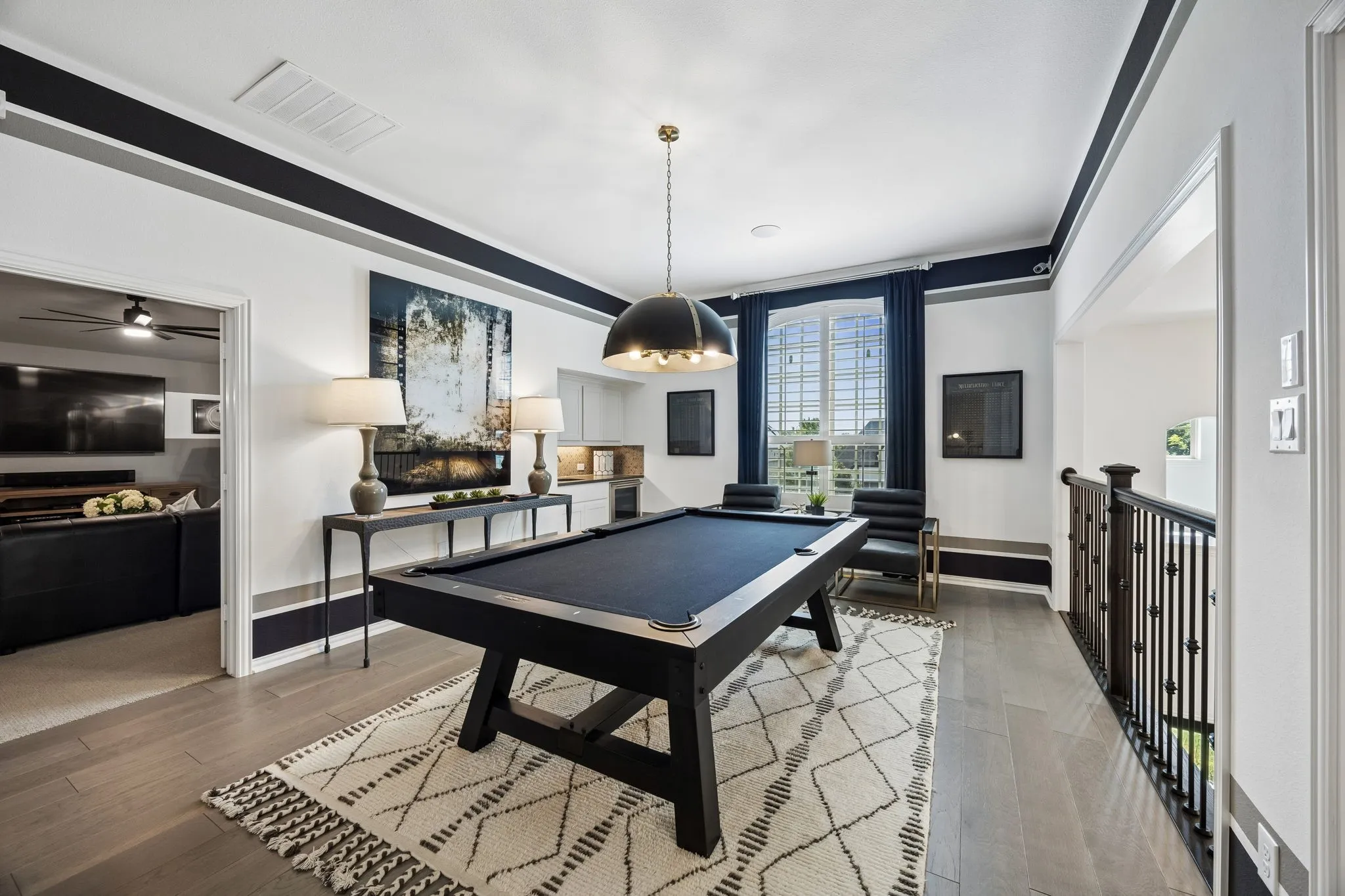 Game room has a wet bar and beverage fridge.