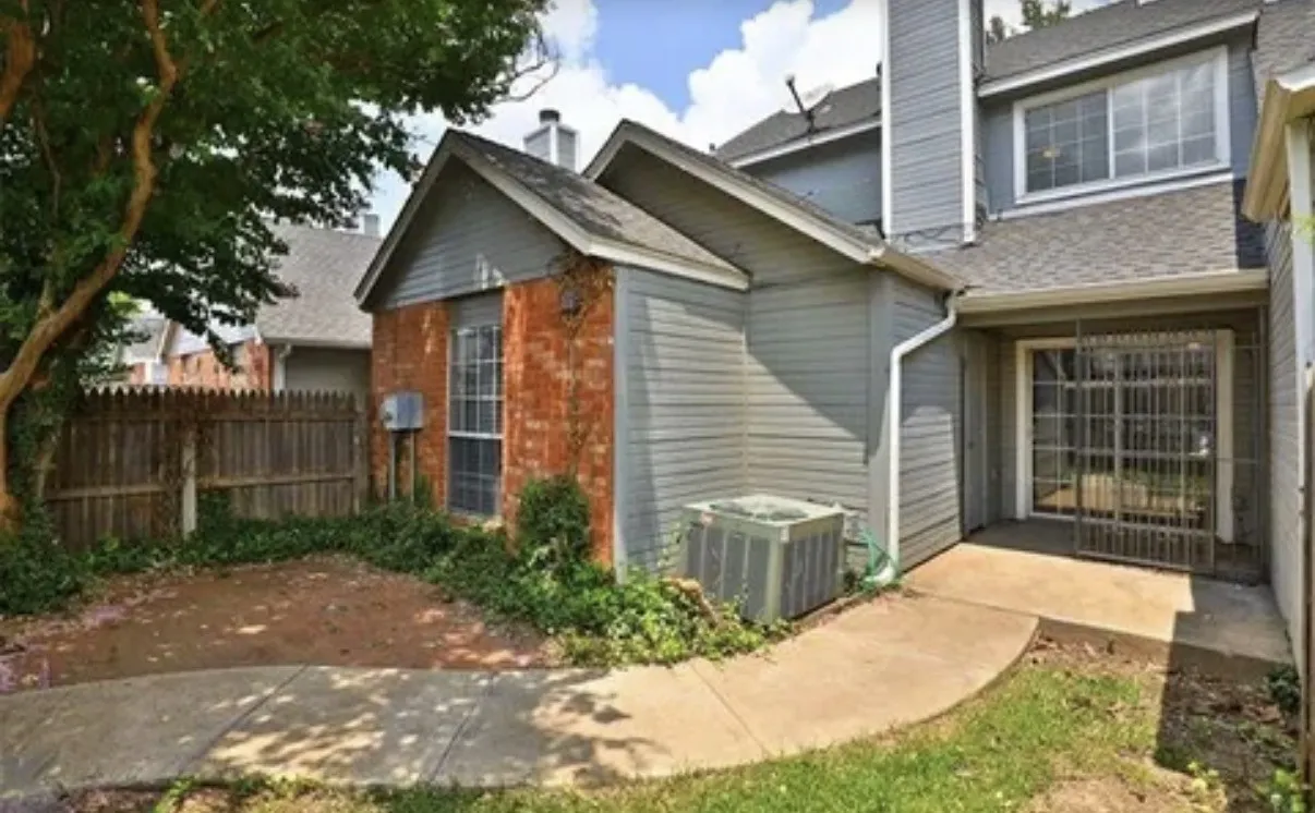 Exterior featuring a combination of brick and horizontal siding, concrete patio, perimeter wood fencing, and mature landscaping