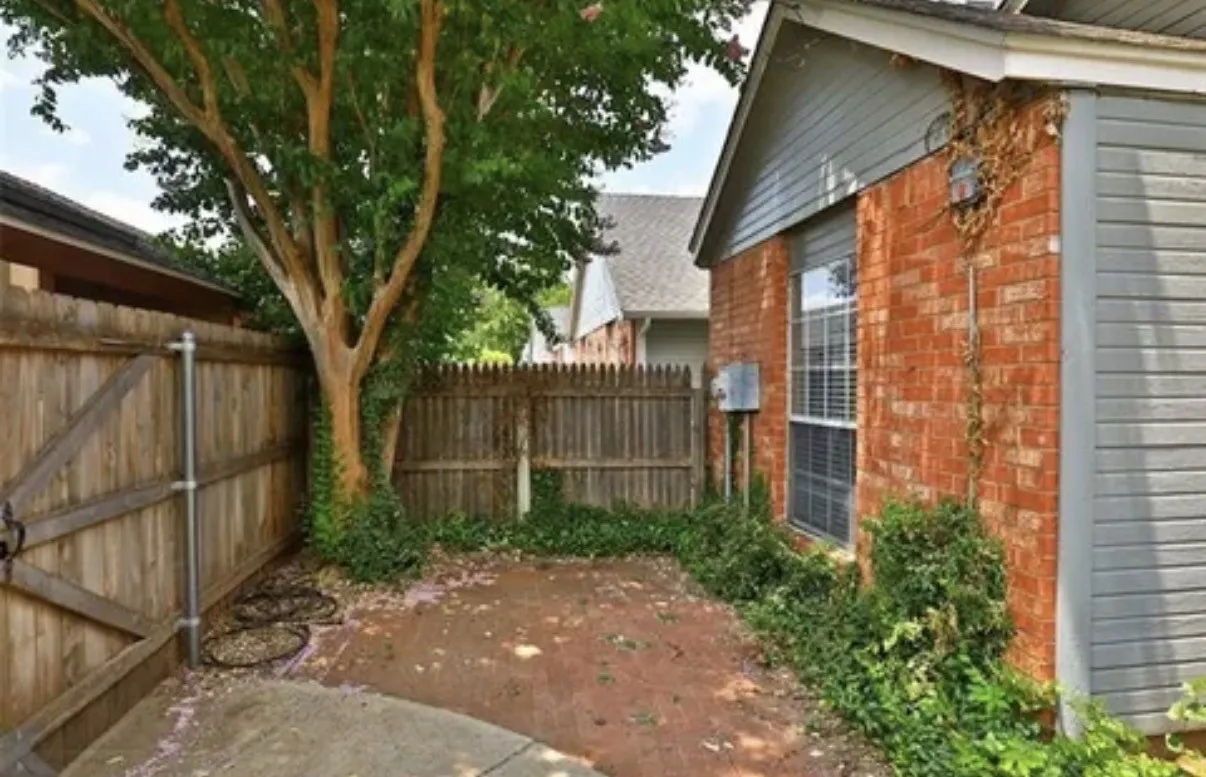 Brick exterior with wood-finish siding, fully fenced yard, and concrete patio
