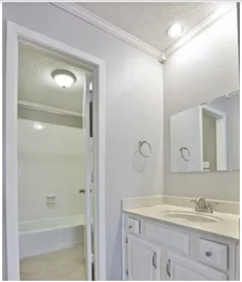 Vanity featuring a light-toned countertop, integrated basin, and white cabinetry