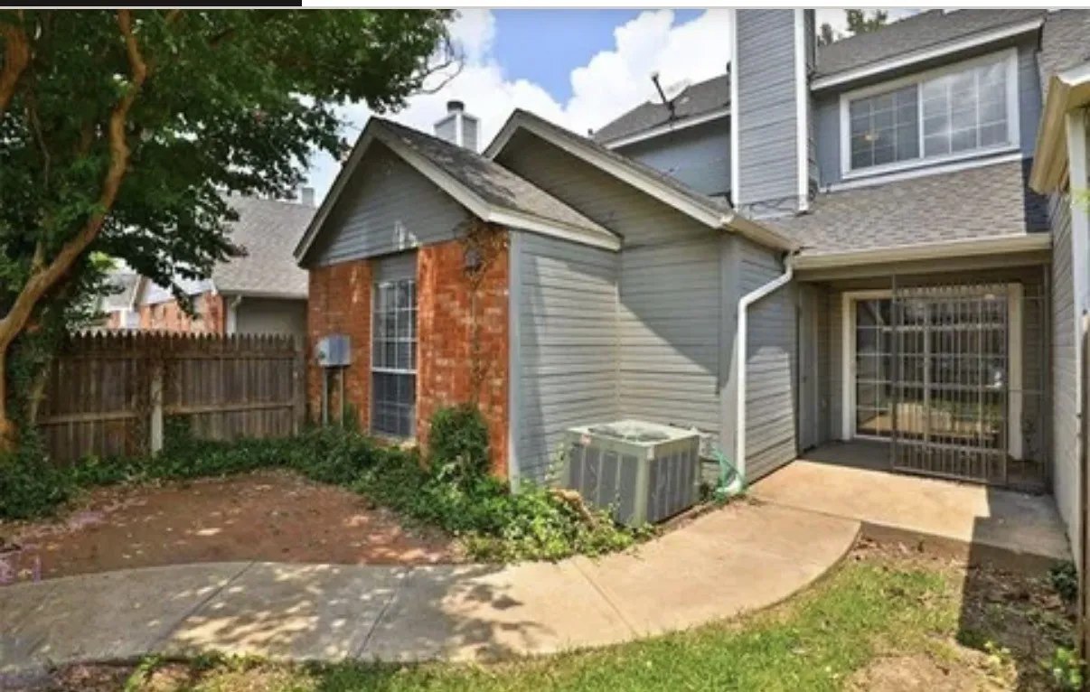 Multi-level exterior featuring a combination of brick and horizontal siding, a concrete patio, and a wood privacy fence