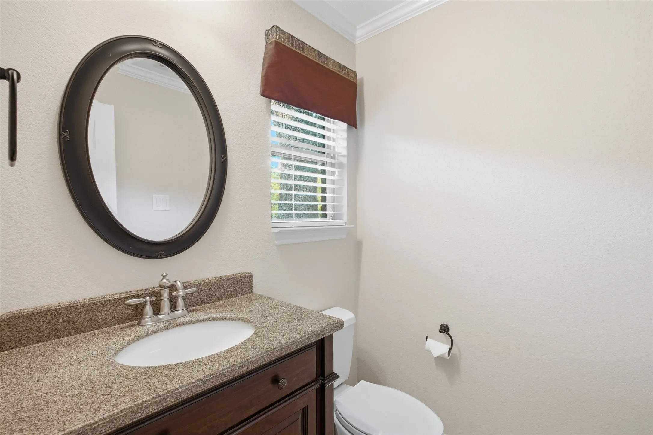 Convenient powder bath with granite vanity and oil-rubbed bronze accents for guests.