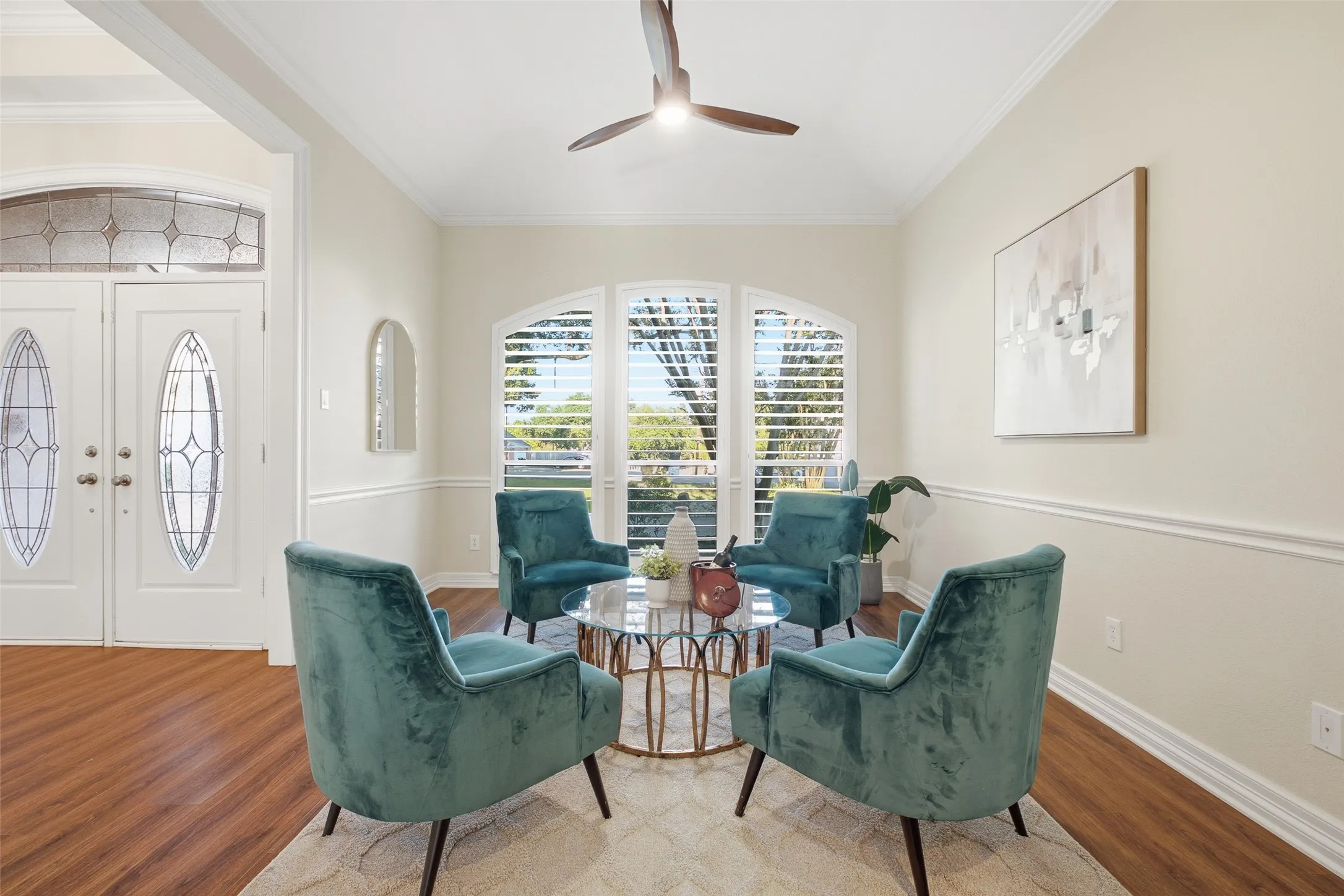 Bright front sitting room with arched plantation-shuttered windows: perfect for morning coffee or quiet conversation.