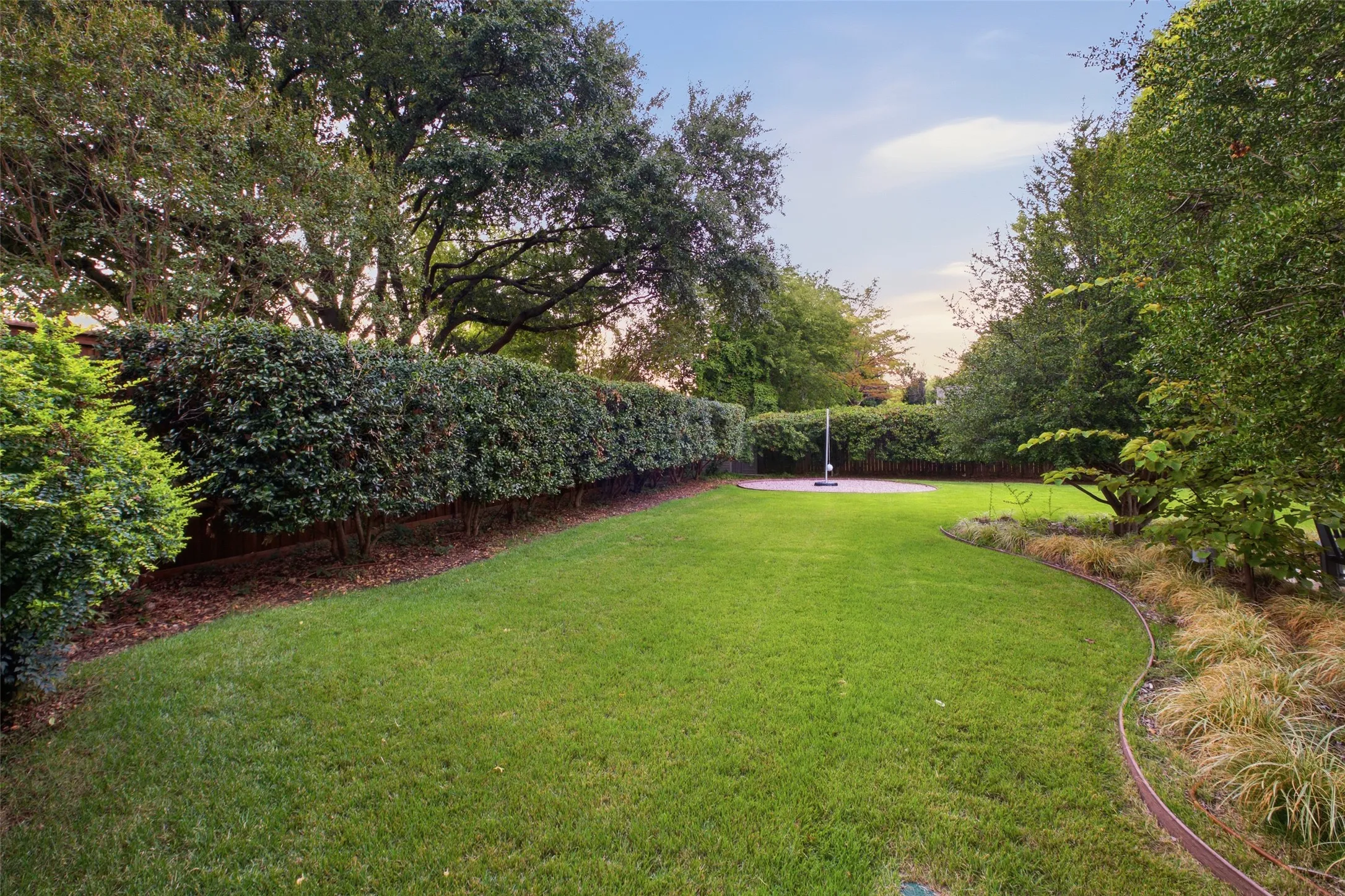 Wide-open, hedge-lined backyard with room for play, pets and gatherings.