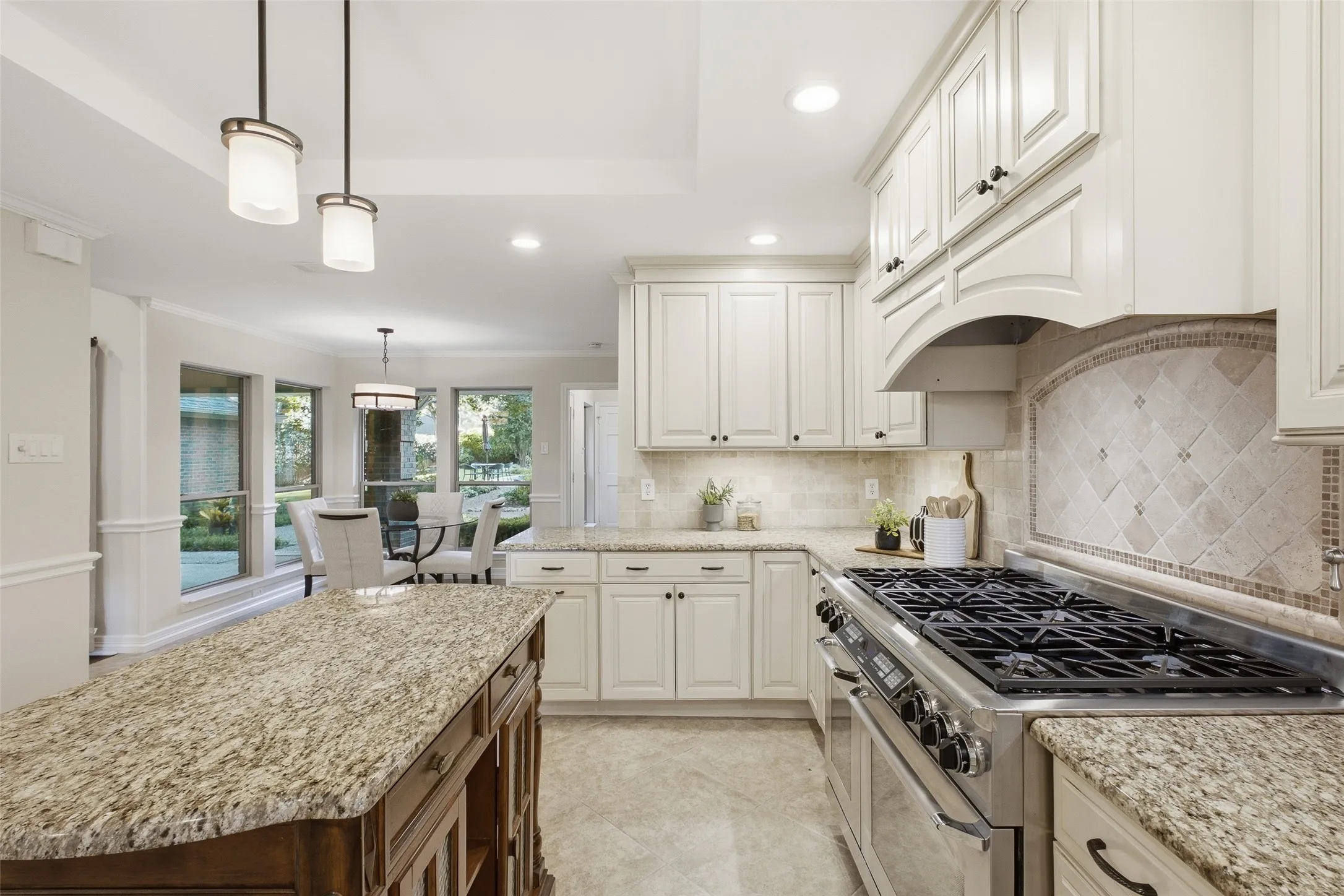 Arched range hood and mosaic-inlay backsplash add custom character to the heart of the home.