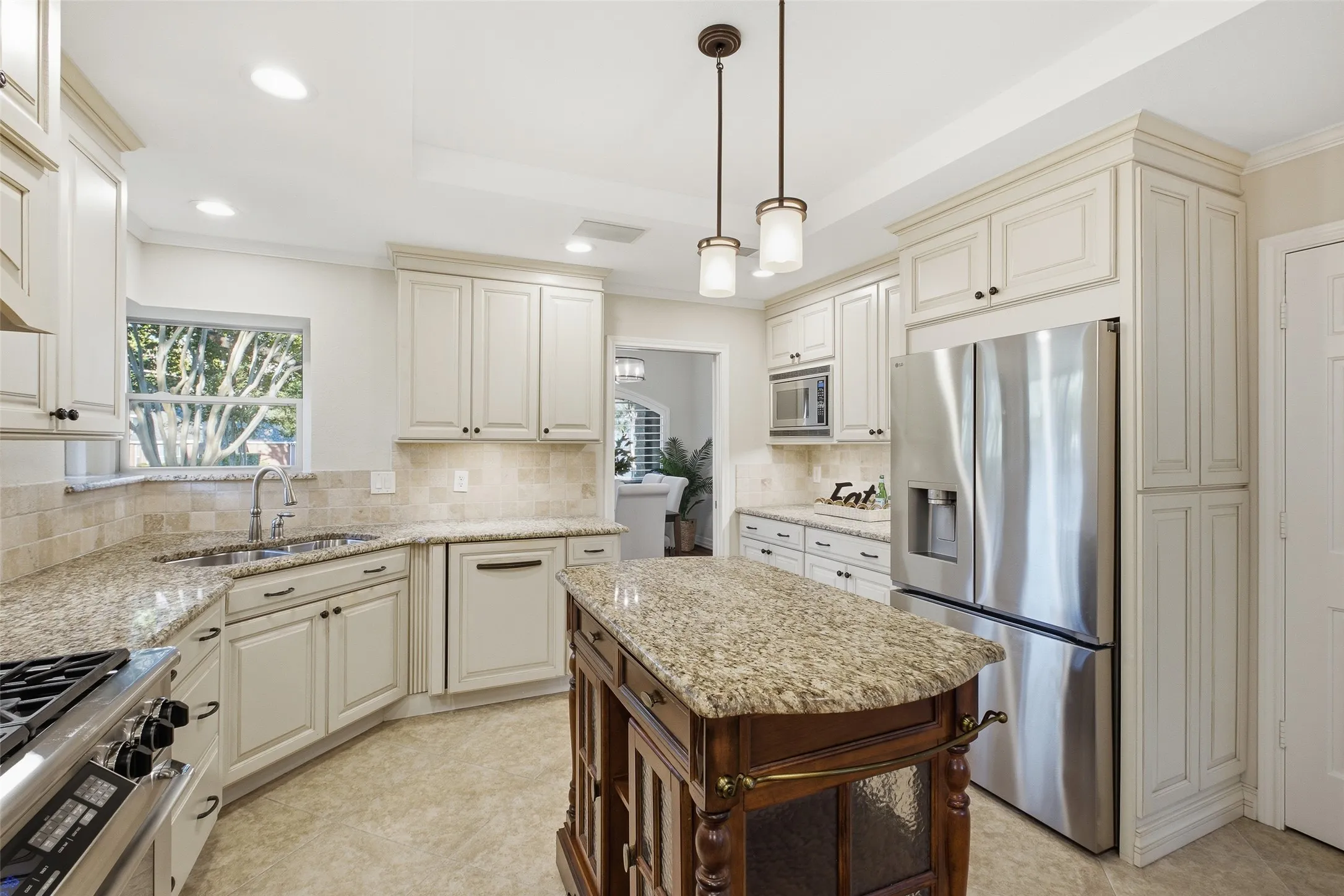 Cook with a view: sunny corner window over the sink, granite counters, built-in microwave and abundant cabinetry.