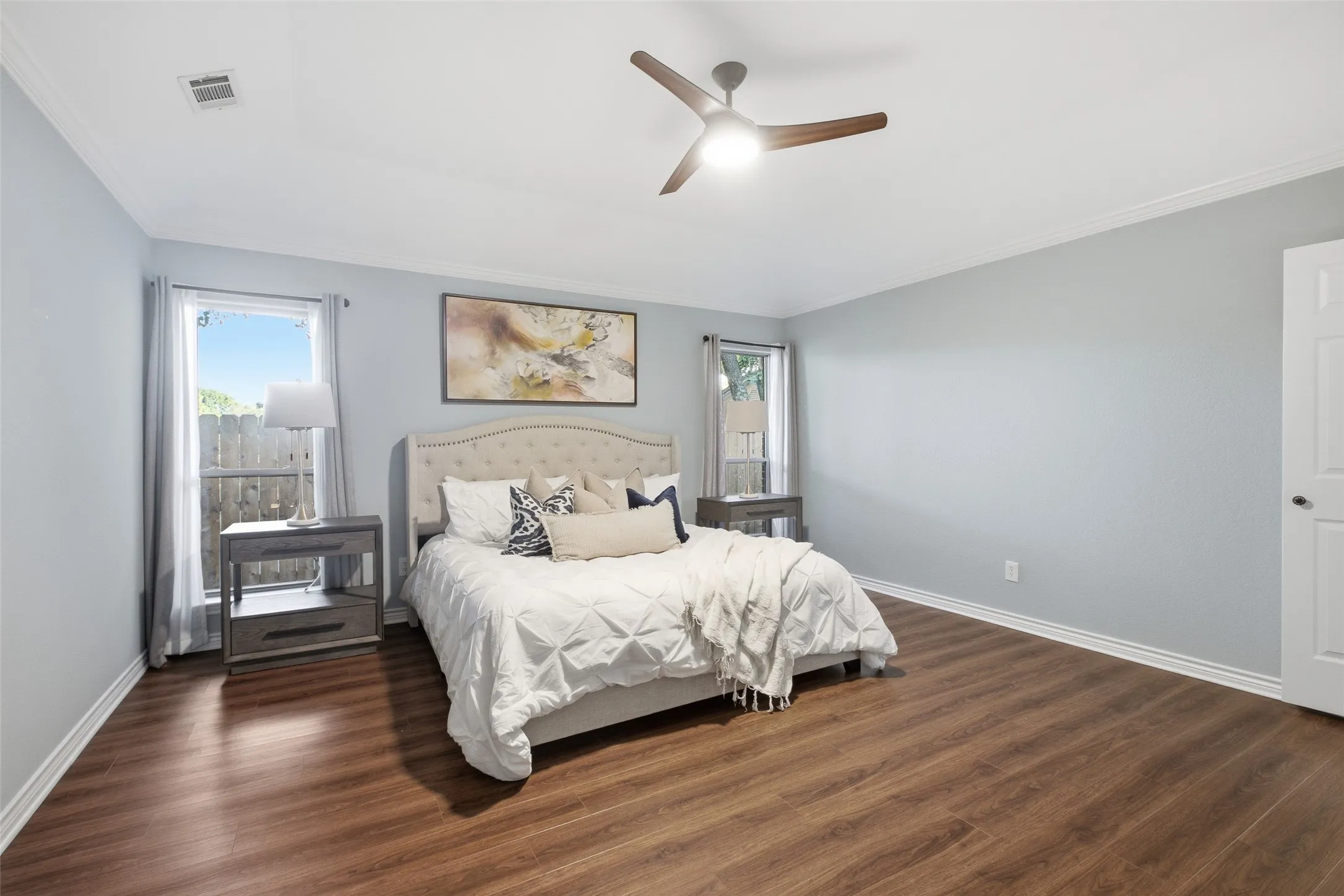 Primary suite with vaulted ceiling, ceiling fan and crown molding: a serene place to unwind.